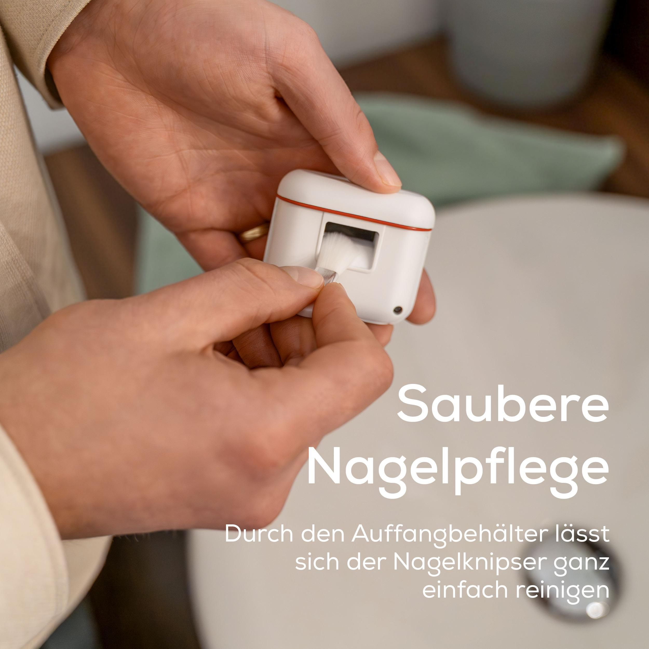 Person reinigt einen kleinen weißen Nagelkneifer mit einer Bürste über einem Waschbecken.