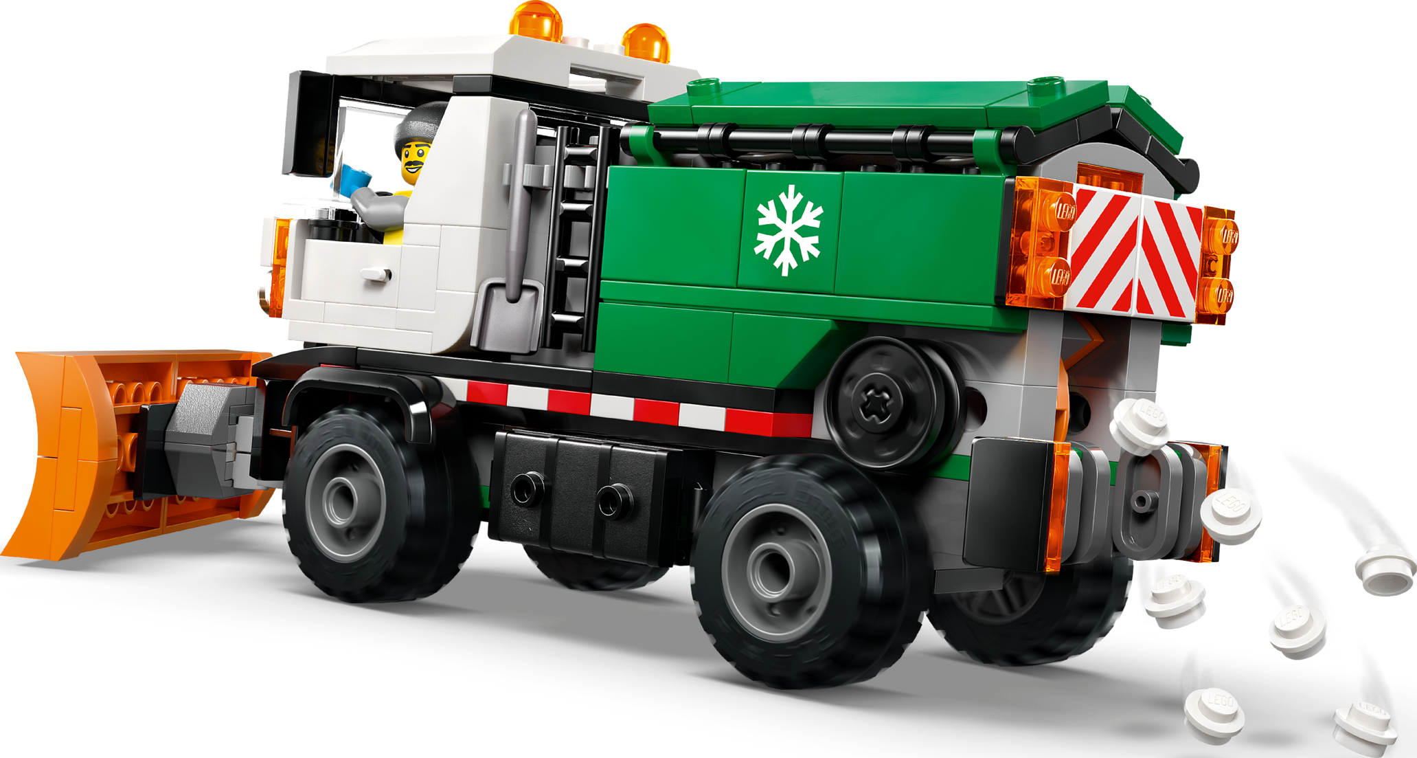 Un camion chasse-neige Lego avec une benne verte et une lame orange répand de petites pièces.