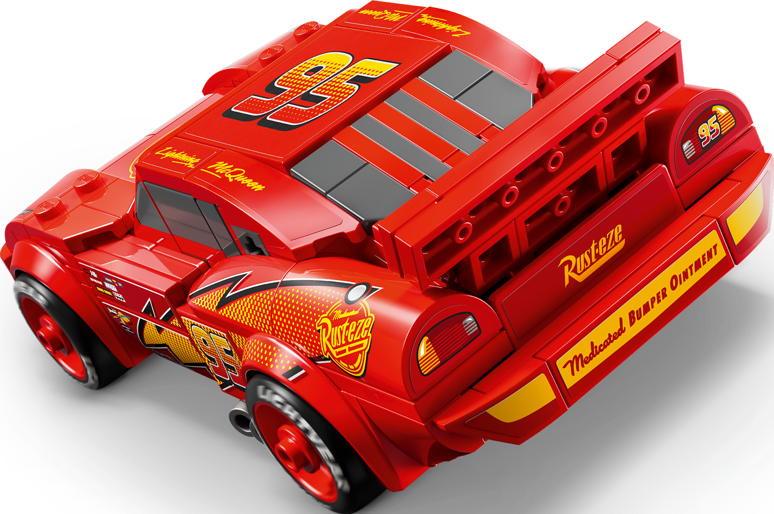 Une voiture jouet LEGO Flash McQueen rouge sur fond noir, vue de dos.
