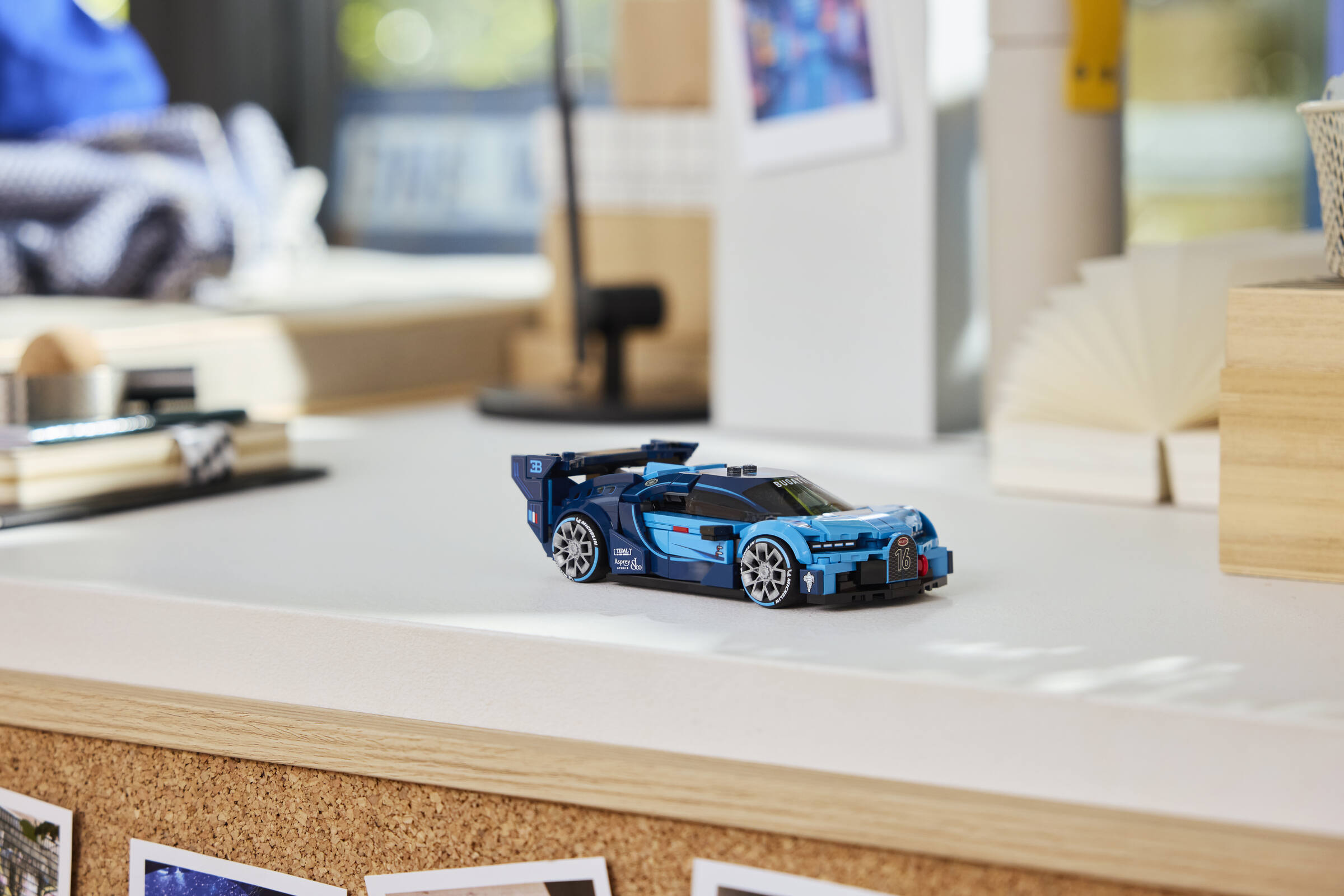 Une voiture Lego bleue posée sur une table blanche dans une pièce.