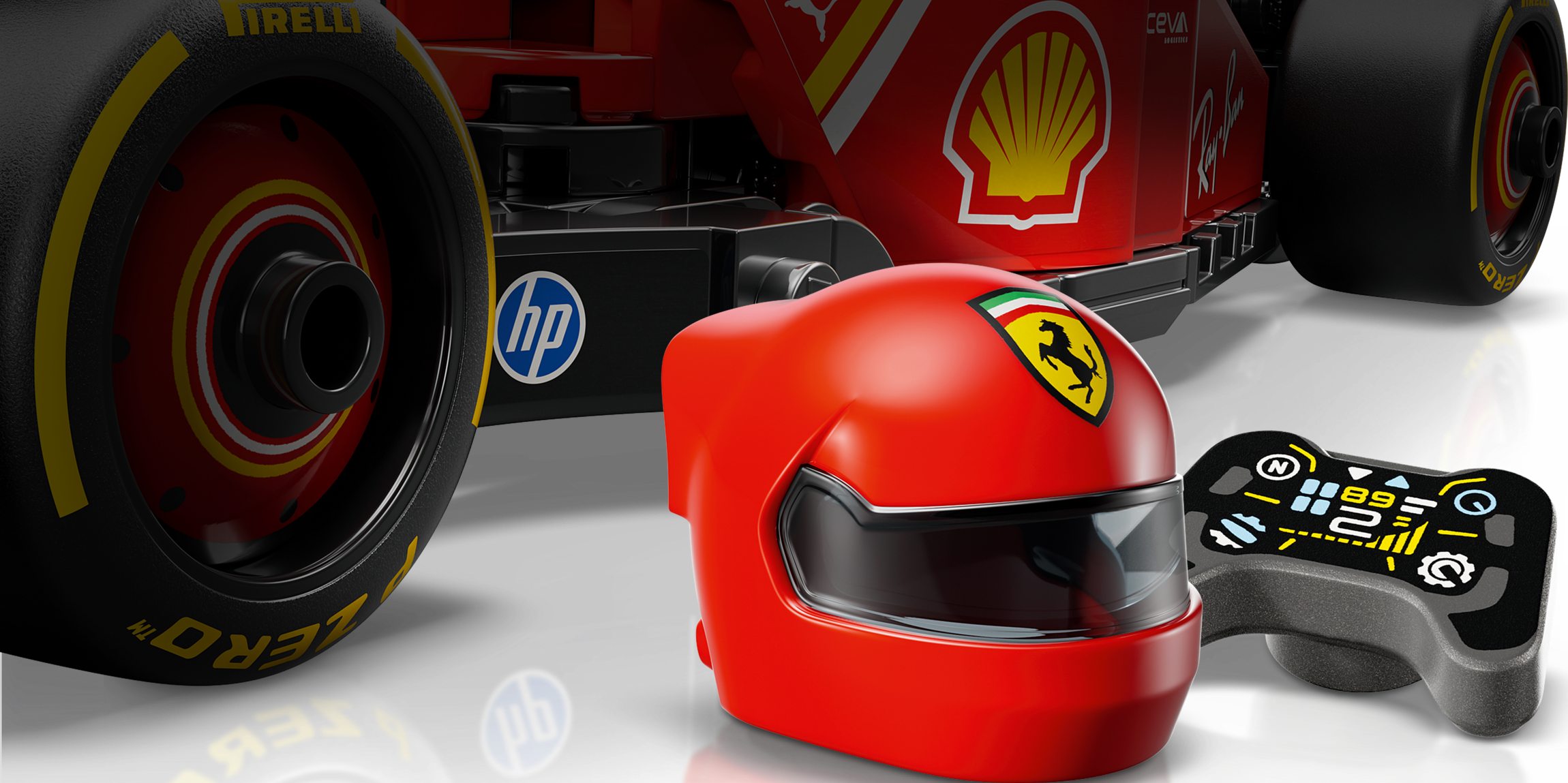 Ein roter Ferrari-Spielzeughelm vor einem Formel-1-Spielzeugauto, daneben eine Fernbedienung.