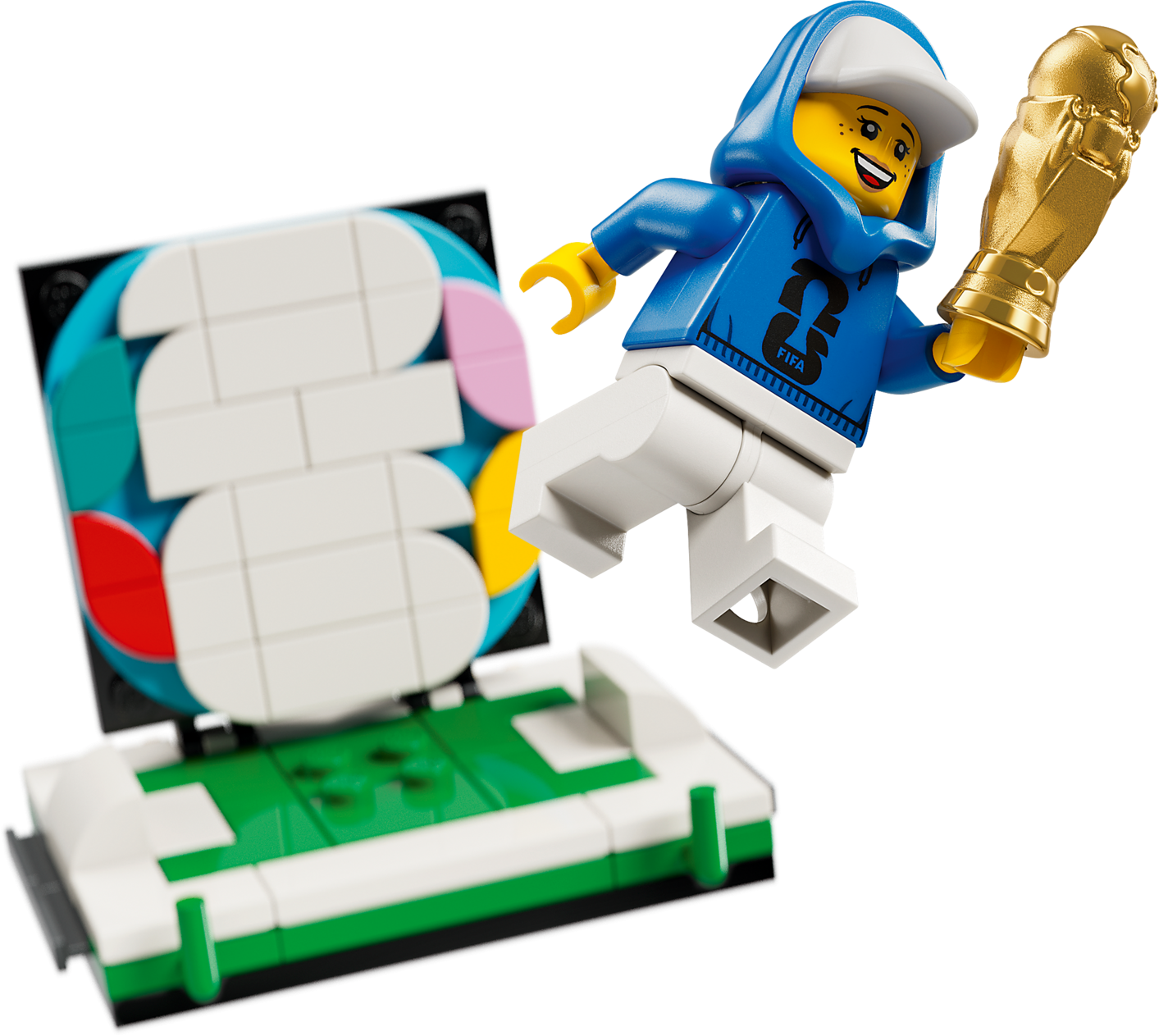 Lego-Minifigur im blauen Hoodie springt über ein Lego-Fußballfeld und hält einen goldenen Pokal.