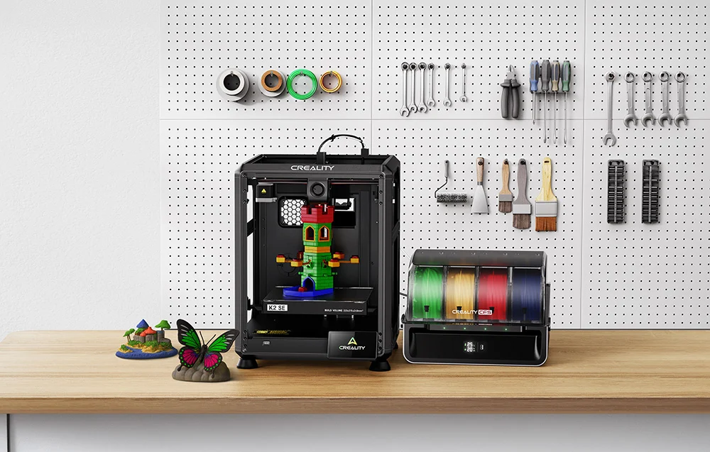 Színes tornyot nyomtató 3D-nyomtató áll egy faíróasztalon szerszámos fal előtt.