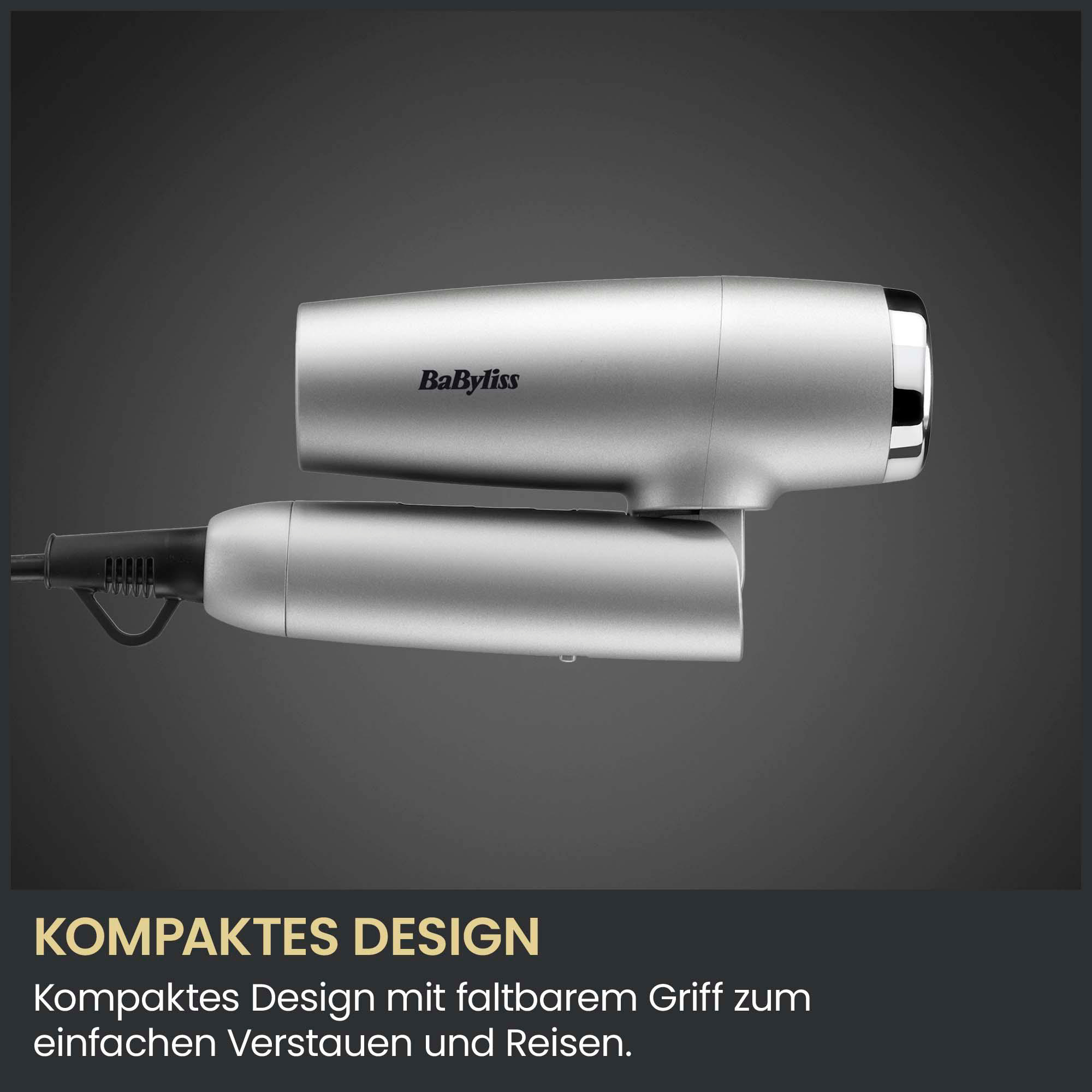 Silberner BaByliss Haartrockner mit klappbarem Griff und schwarzem Kabel vor grauem Hintergrund.