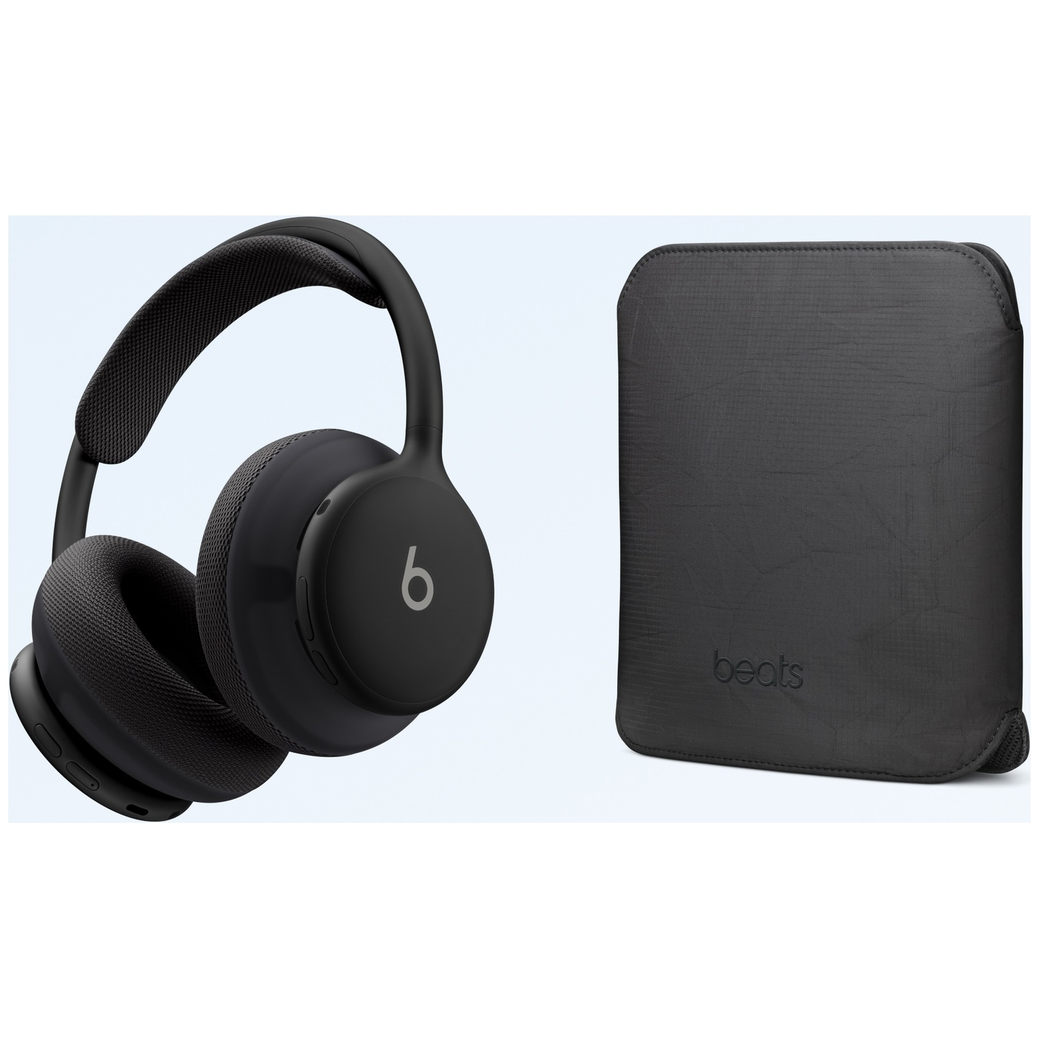 Casque Beats noir avec coussinets et étui en tissu noir assorti sur fond clair.