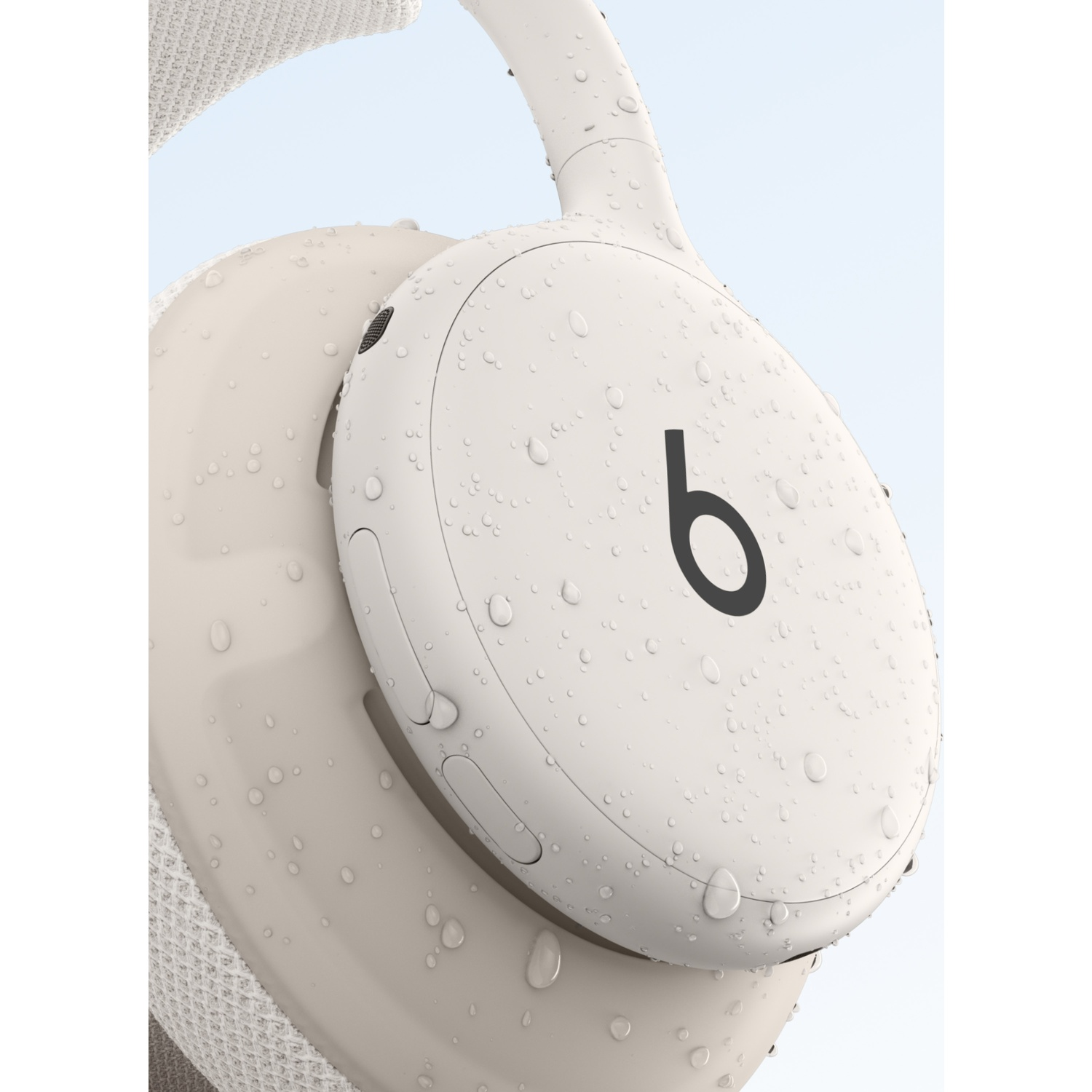 Casque audio de couleur crème recouvert de gouttes d'eau.