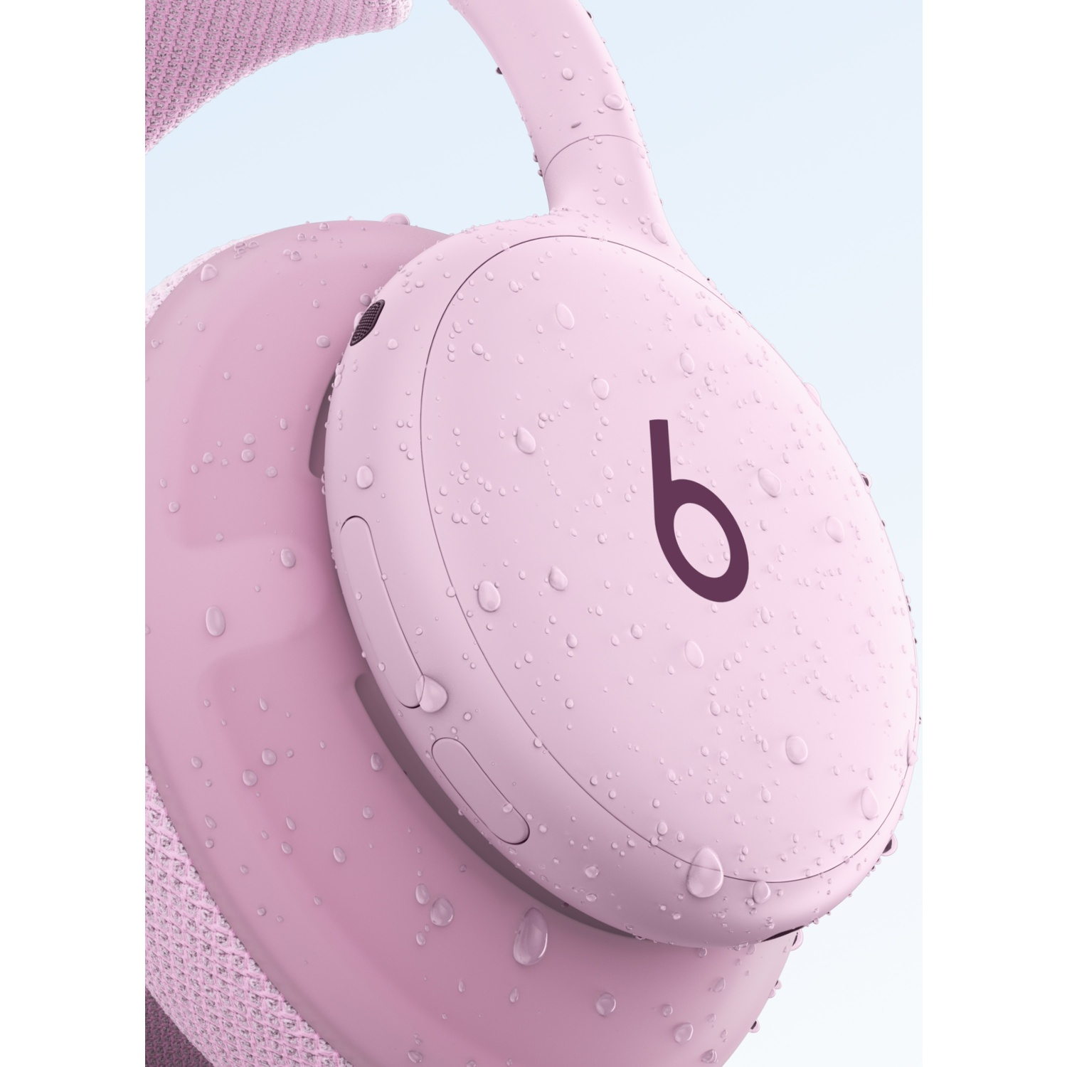 Casque sans fil rose recouvert de gouttes d'eau avec le logo Beats sur le côté.