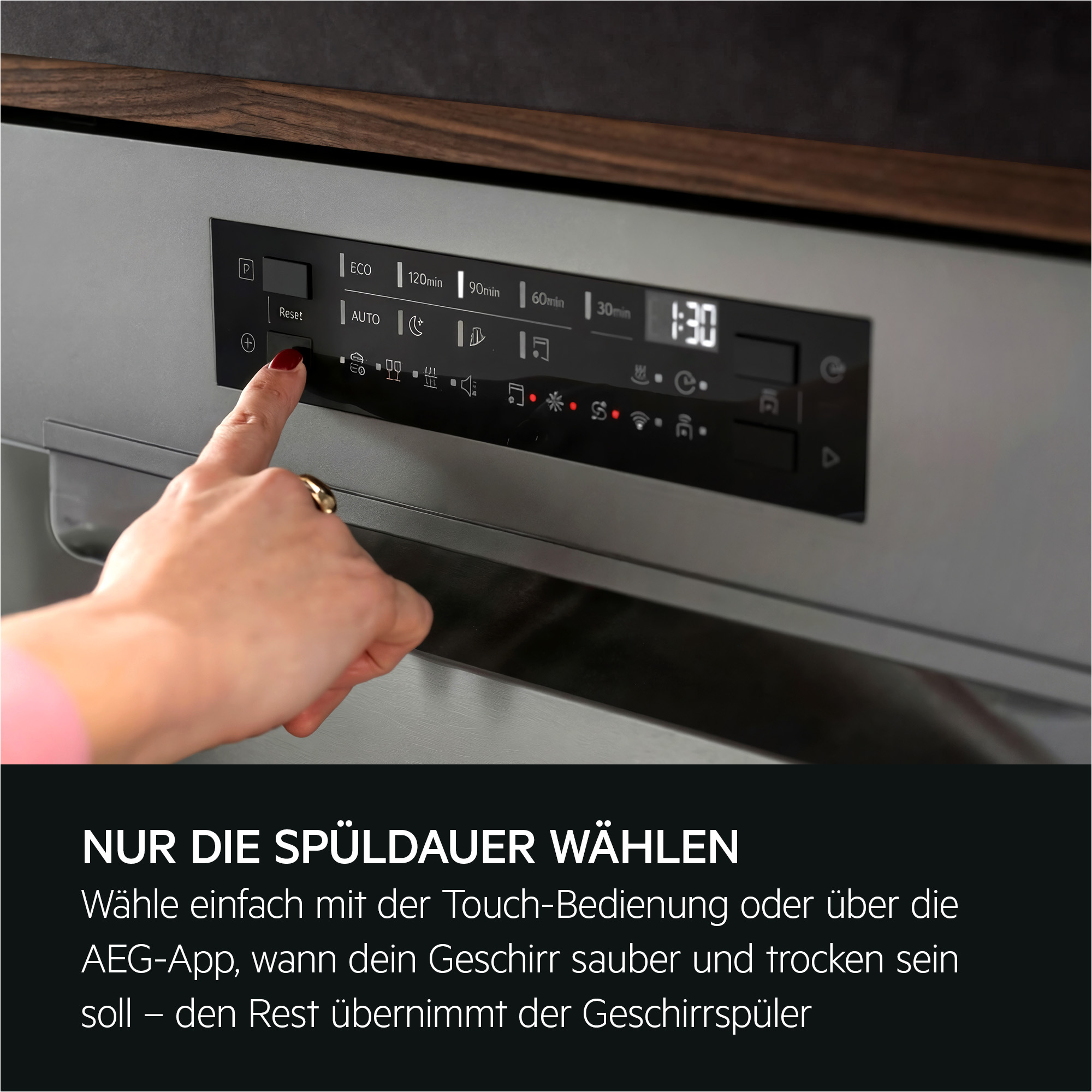 Eine Hand bedient das digitale Touch-Bedienfeld einer grauen Spülmaschine.