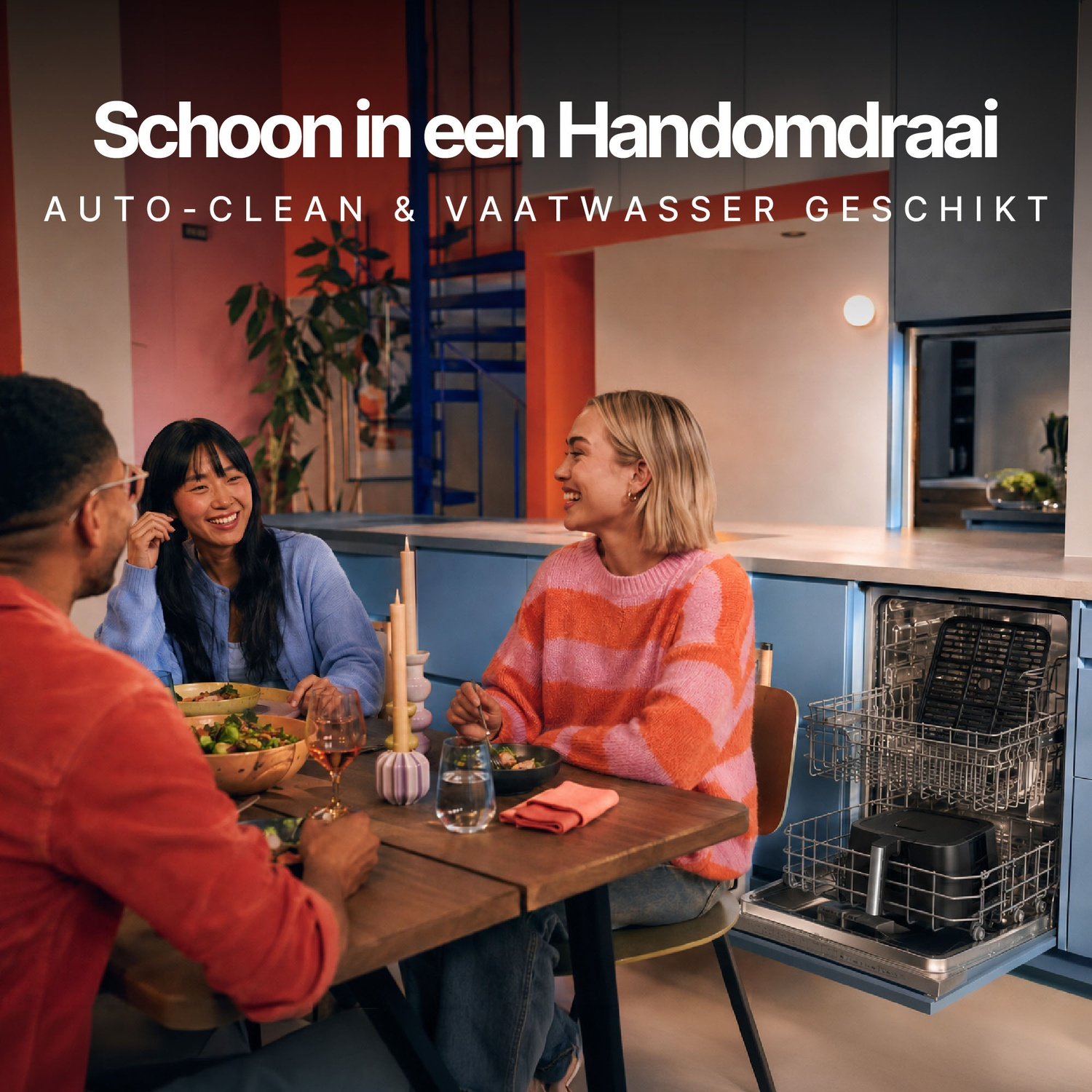 Drie vrienden zitten aan een eettafel in een keuken naast een open vaatwasser.
