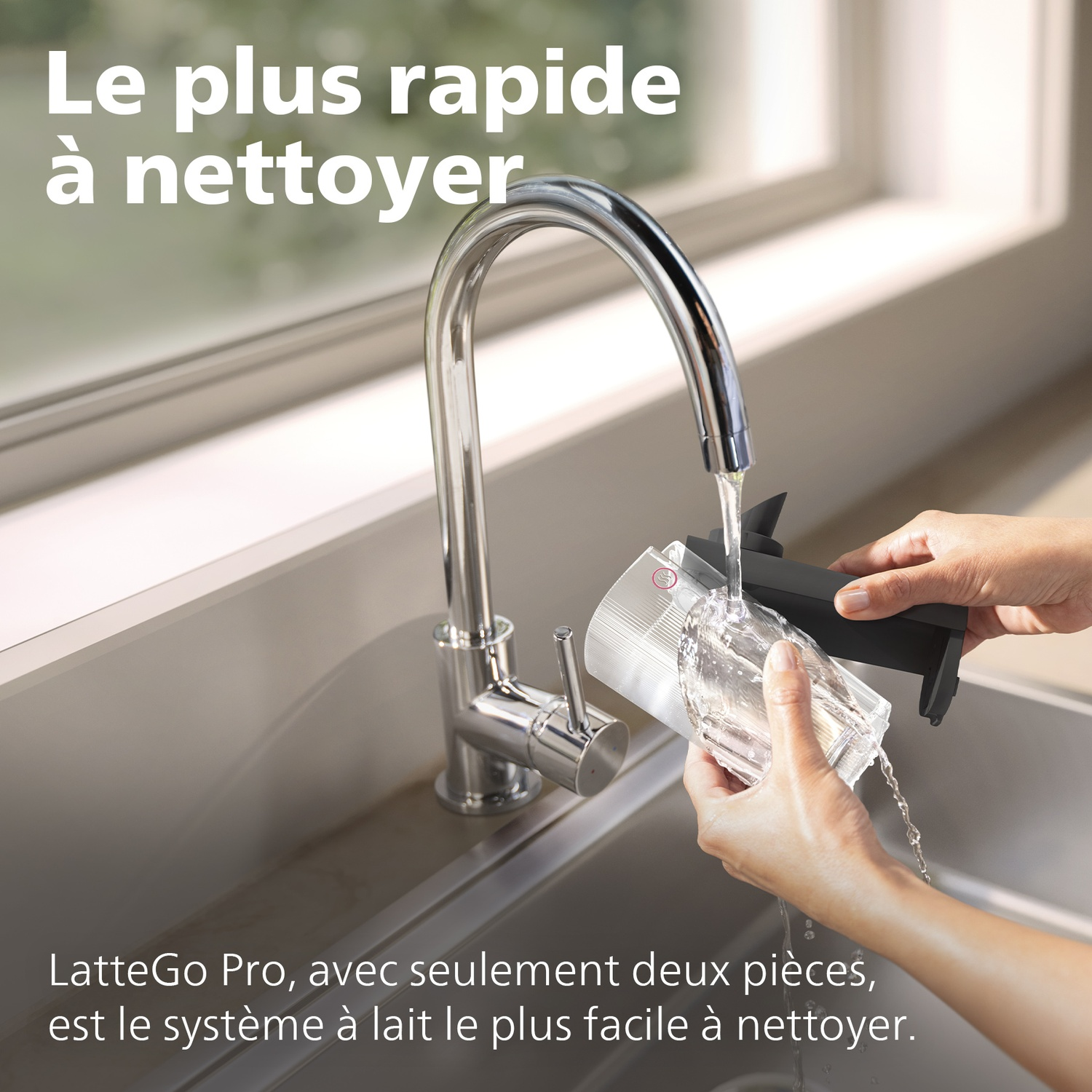 Quelqu'un lave des pièces d'un système à lait sous l'eau courante d'un évier.