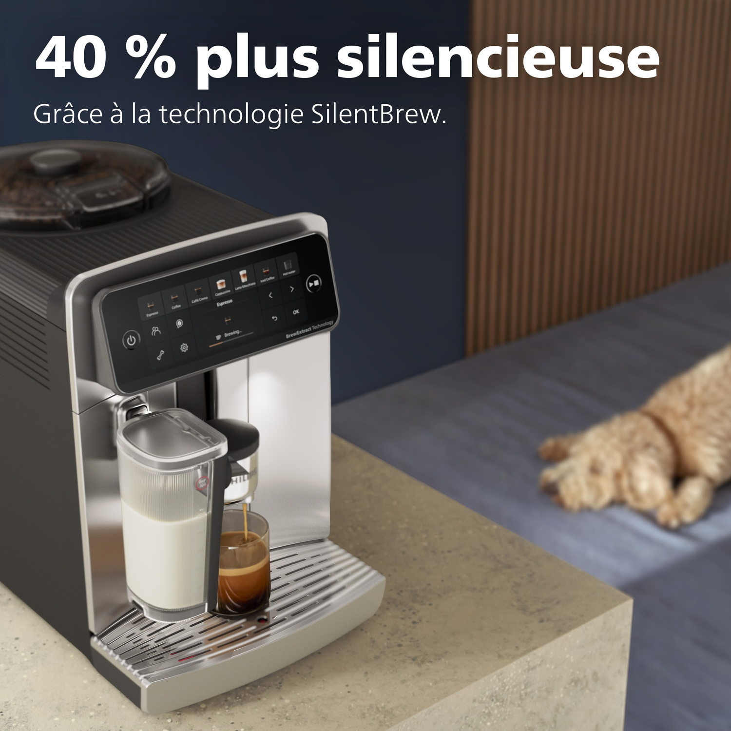Une machine à café verse du café dans un verre. Un chien se repose sur un lit en arrière-plan flou.