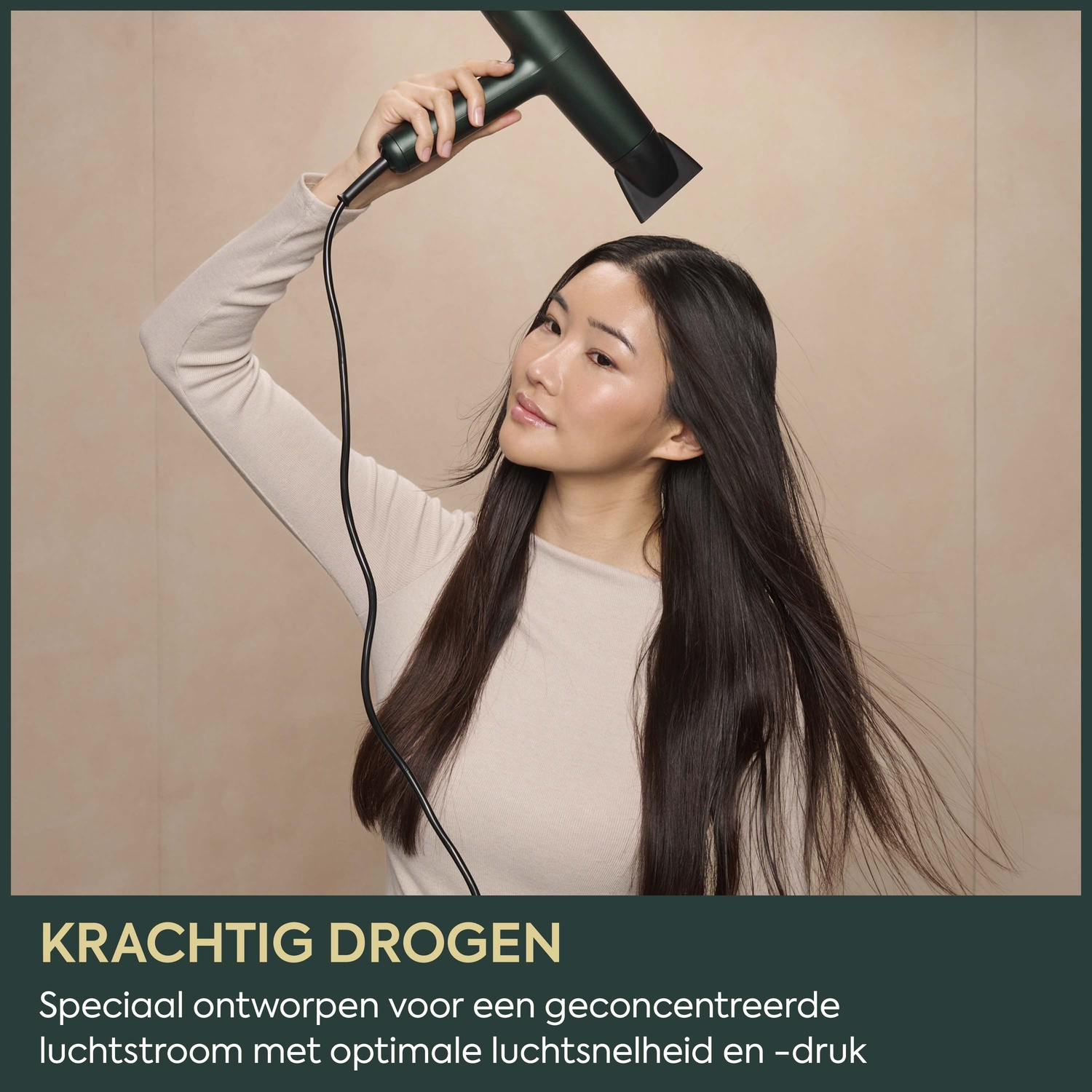 A woman with long dark hair uses a dark green hair dryer, with text at the bottom.