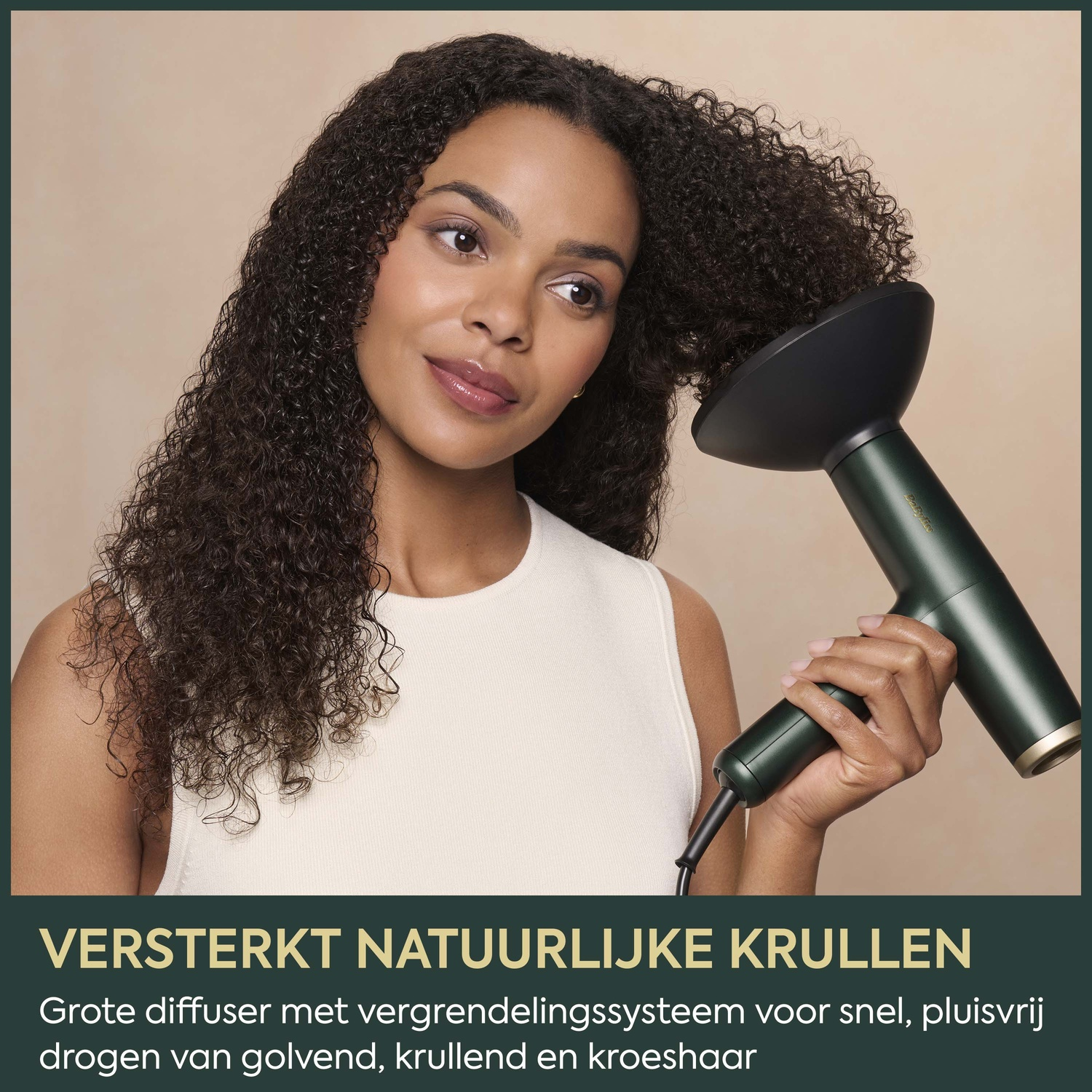 A woman dries her long curly hair with a green hair dryer featuring a diffuser.