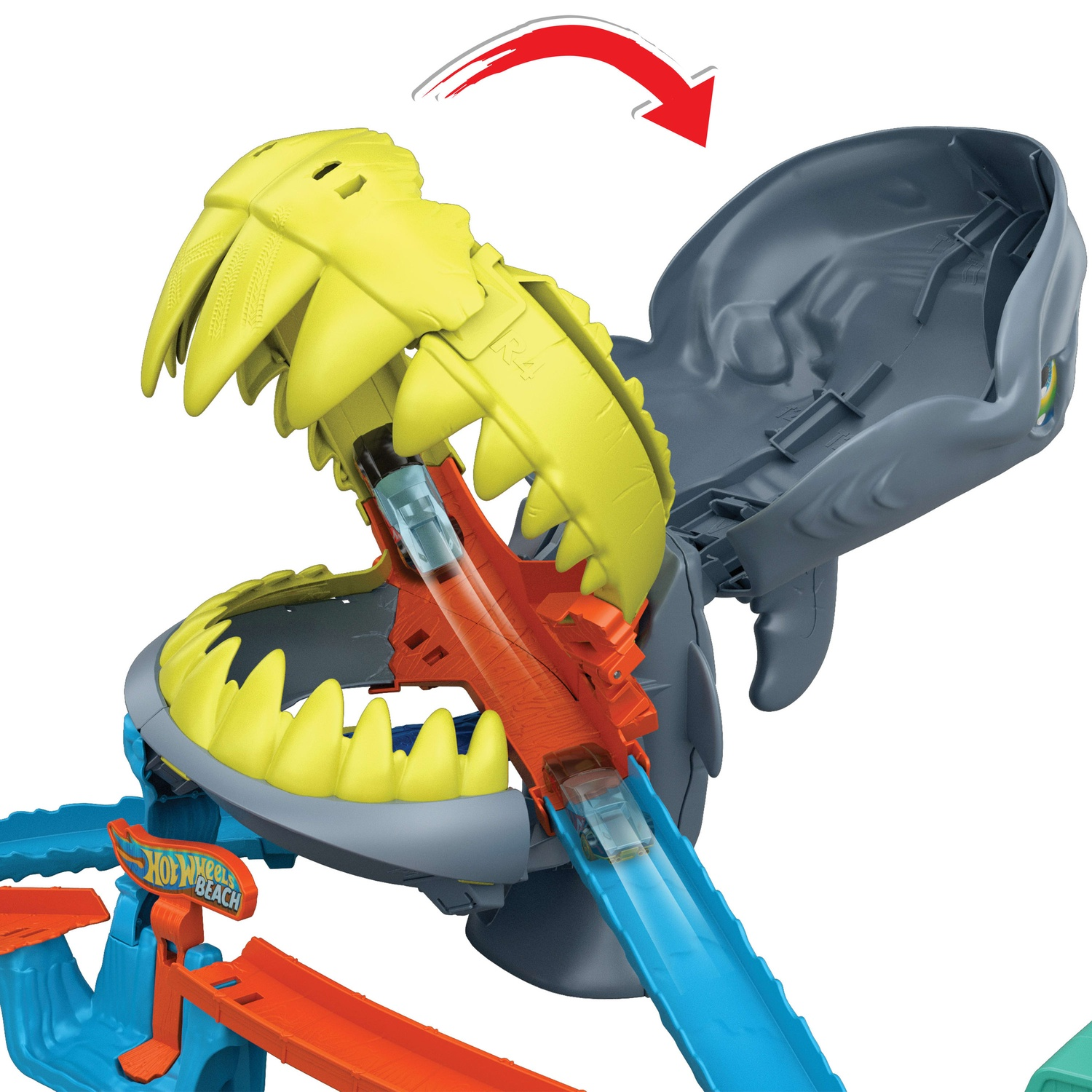 Hot Wheels toy set with a large shark head opening, revealing an orange and blue track with toy cars.