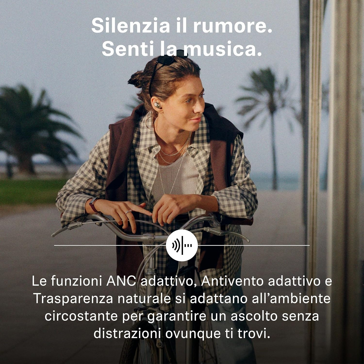 Una donna con auricolari si trova all'aperto con una bicicletta e uno sfondo di palme. Testo sull'immagine.