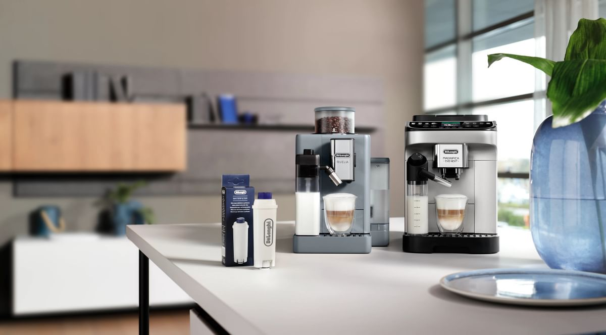 Zwei Kaffeemaschinen und ein Wasserfilter stehen auf einer Arbeitsplatte in einer Küche.
