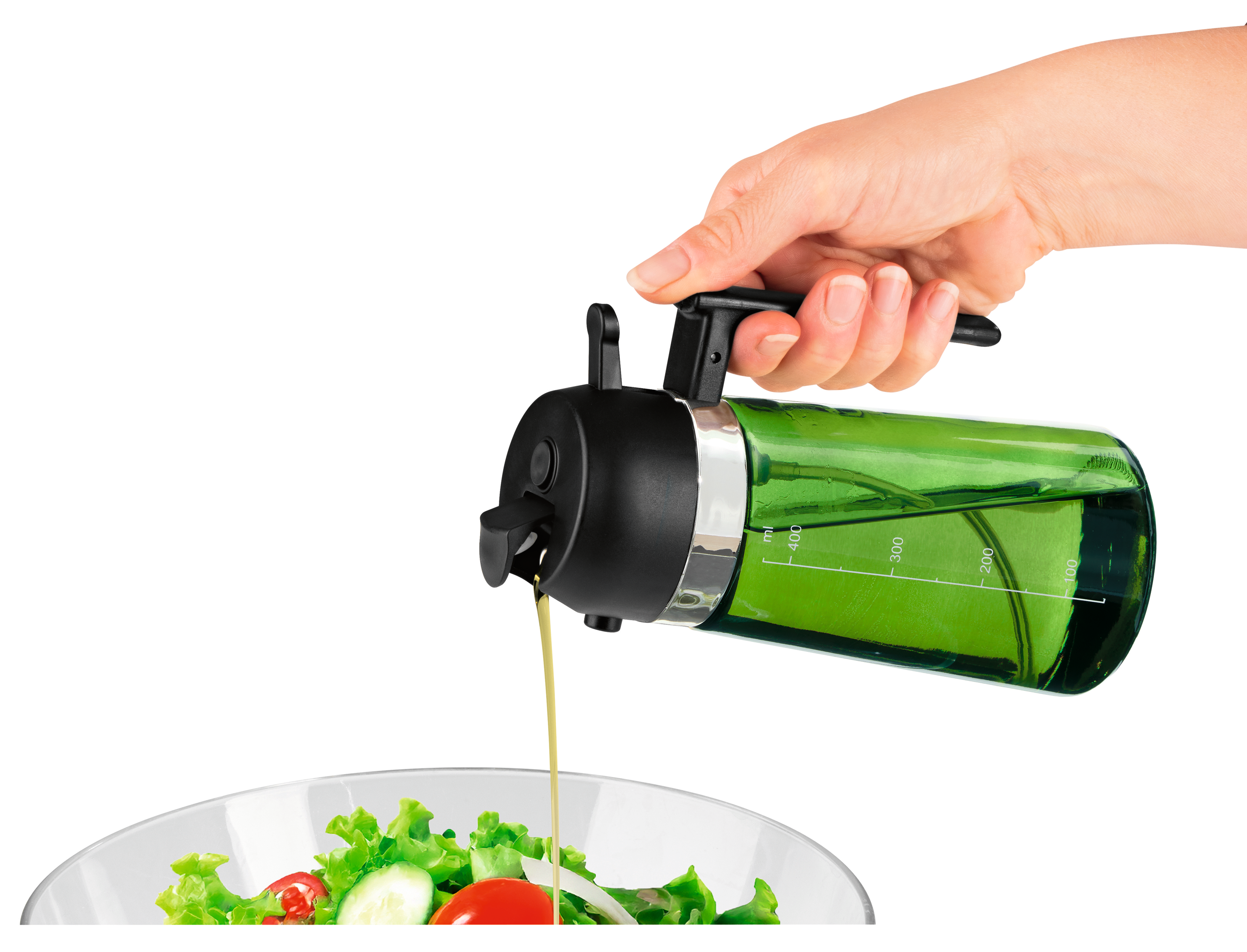 Eine Hand gießt Öl aus einem grünen Spender auf einen frischen Salat.