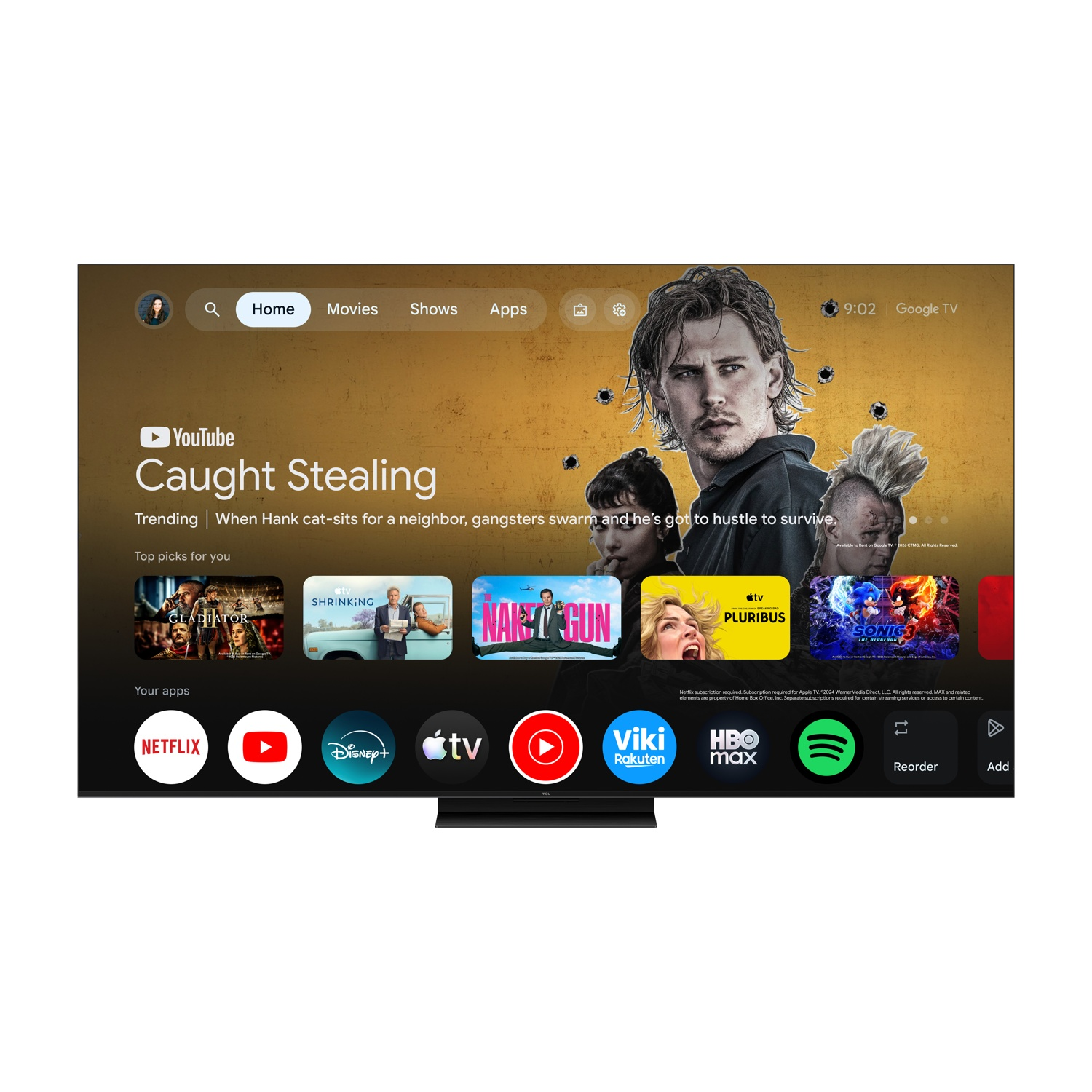 Una TV mostra la schermata iniziale di Google TV con Caught Stealing e vari loghi di app in basso.