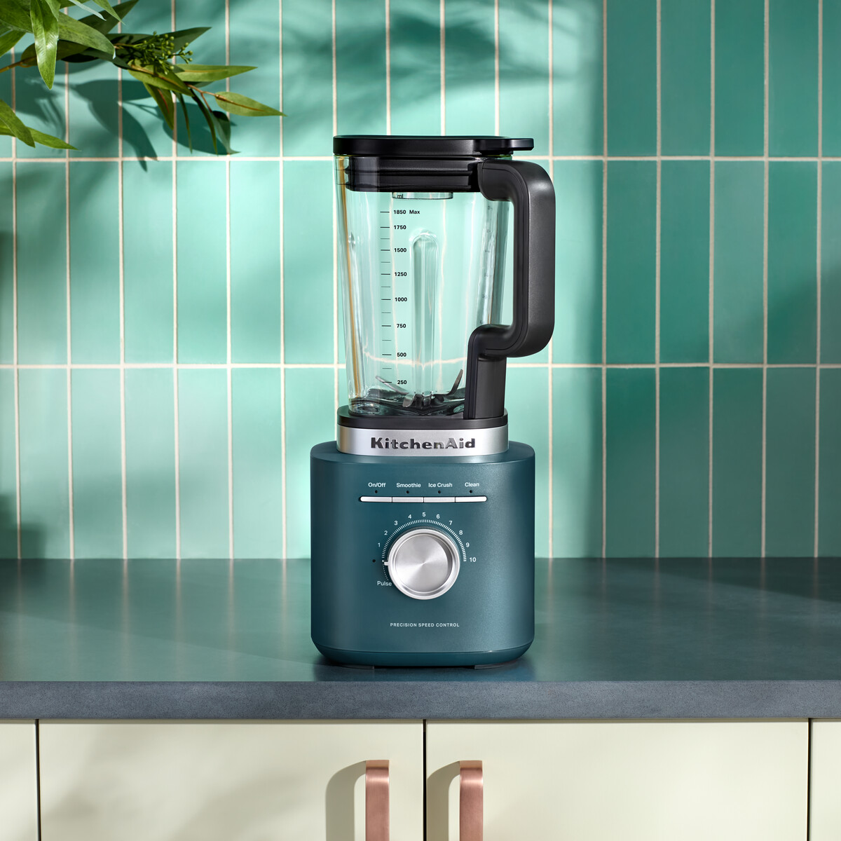 Ein türkisfarbener KitchenAid Mixer steht auf einer Arbeitsplatte vor türkisf Bereichen.