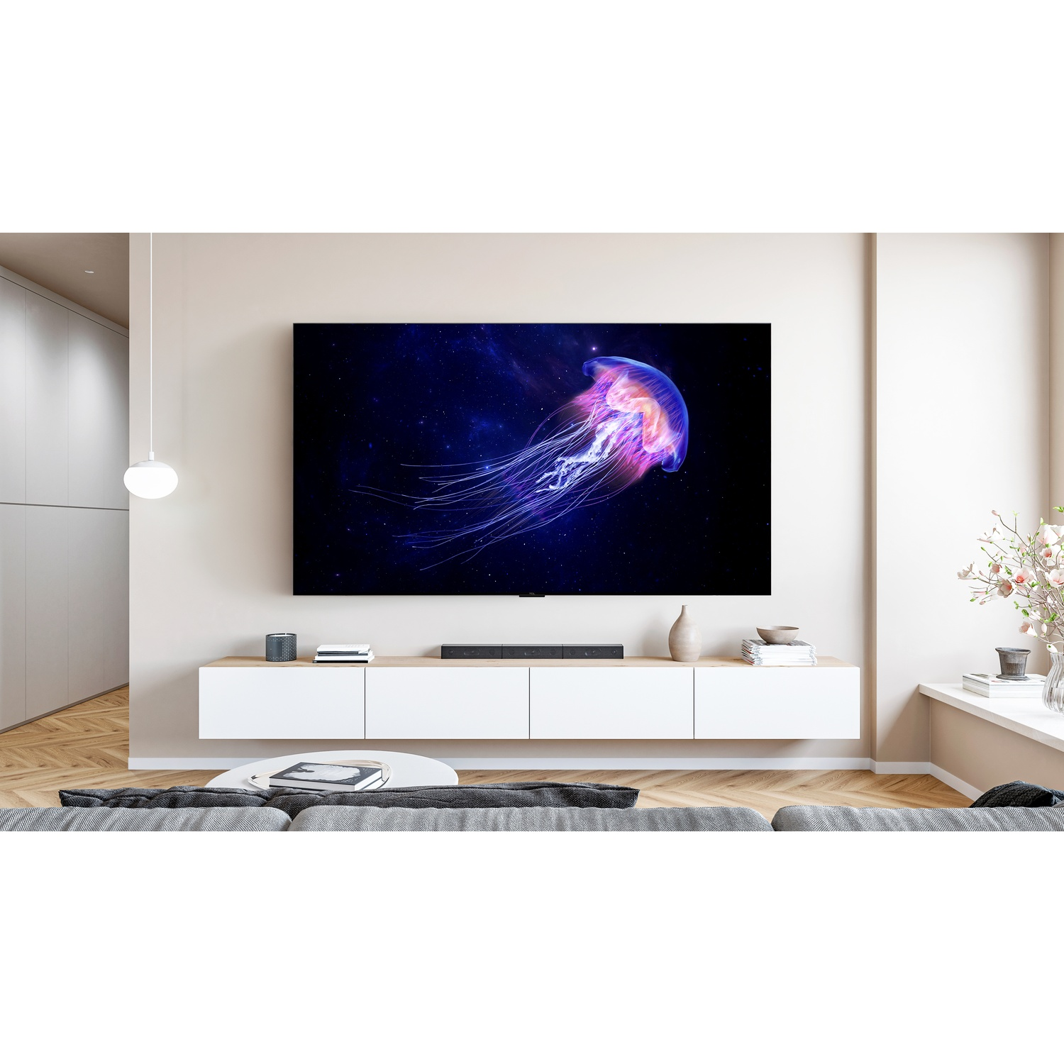 Una grande TV a parete mostra una medusa luminosa su uno sfondo scuro in un soggiorno moderno.