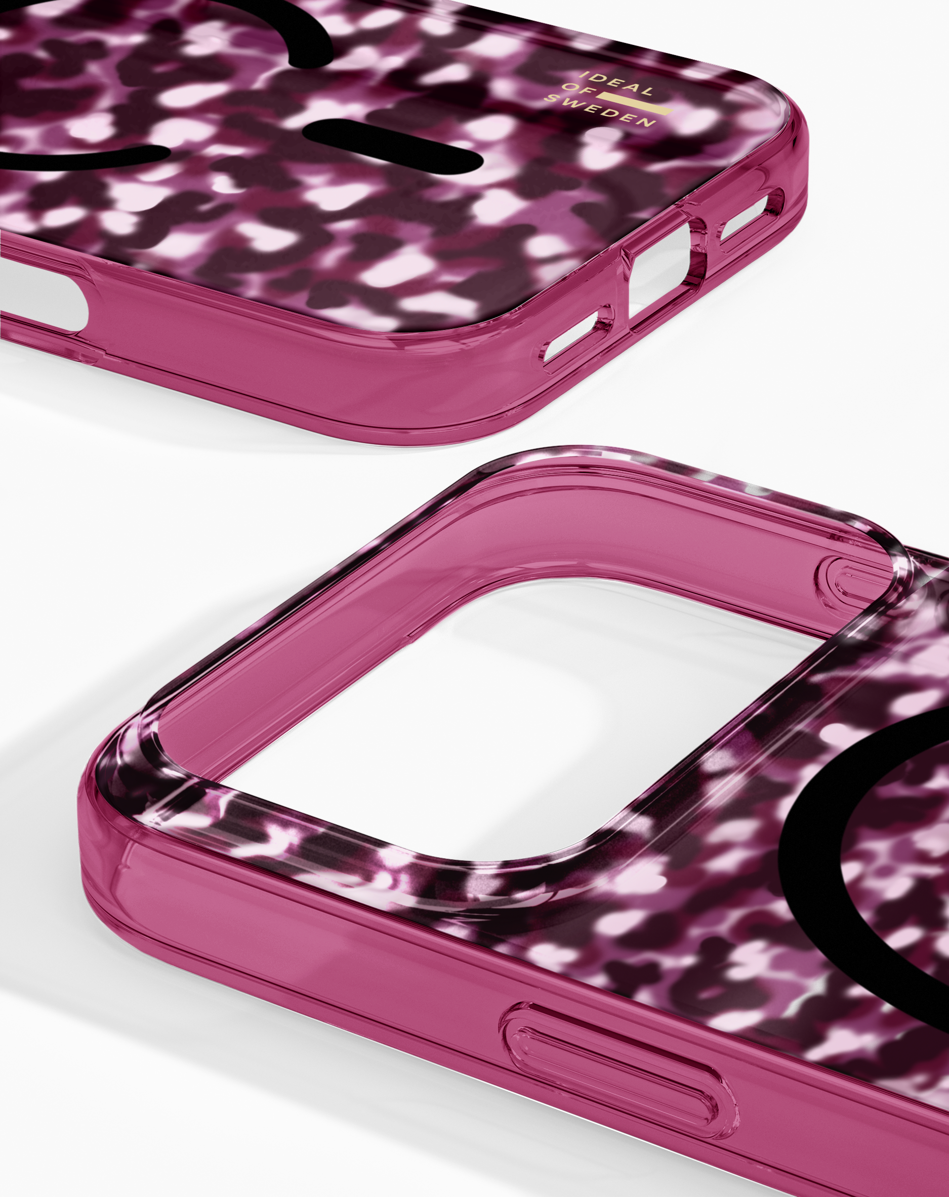 Zwei pinke Smartphone-Hüllen mit weiß-lila Muster und goldenem Logo auf weißem Hintergrund.