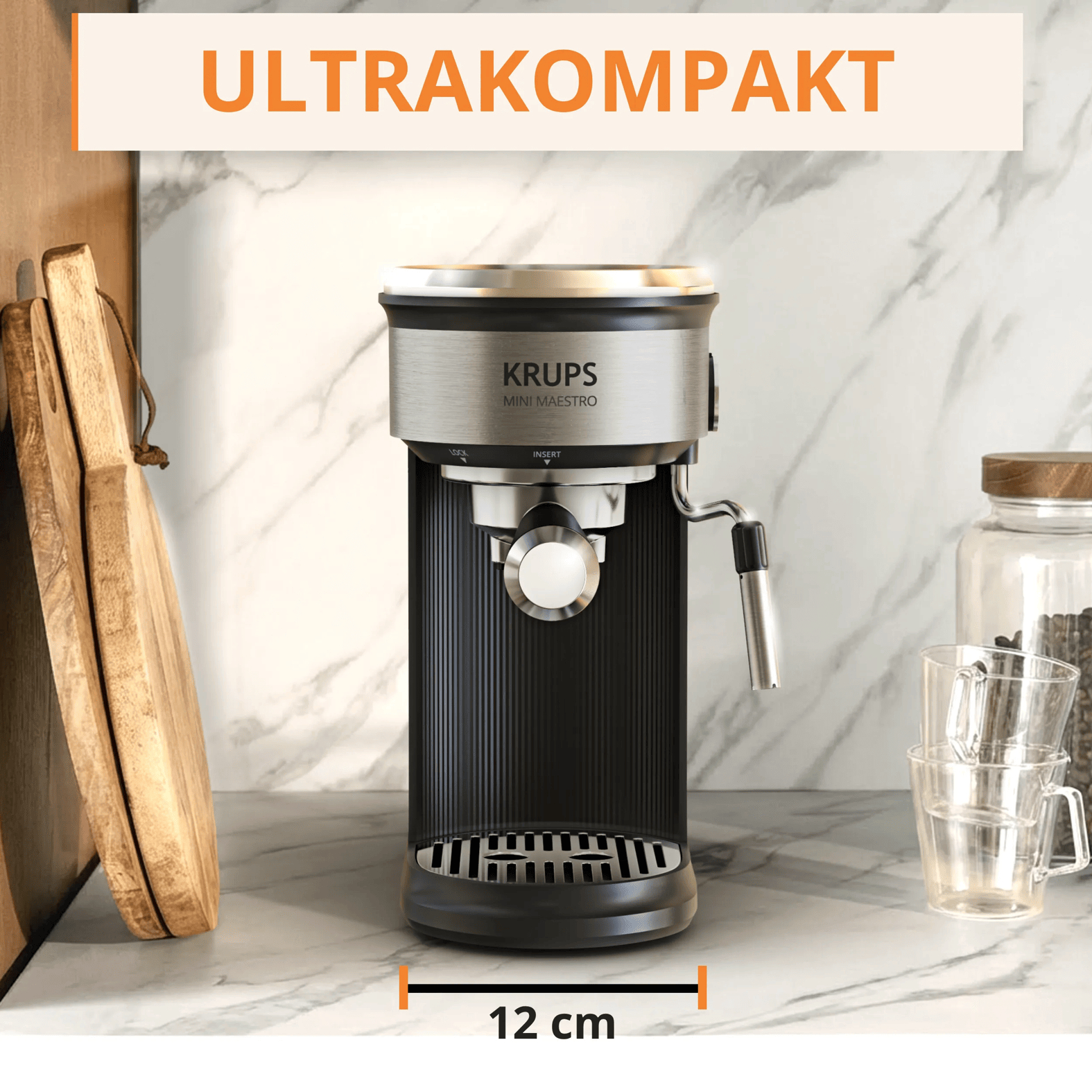 Eine kompakte schwarze und silberne Krups Mini Maestro Kaffeemaschine steht auf einer Marmorarbeitsplatte.