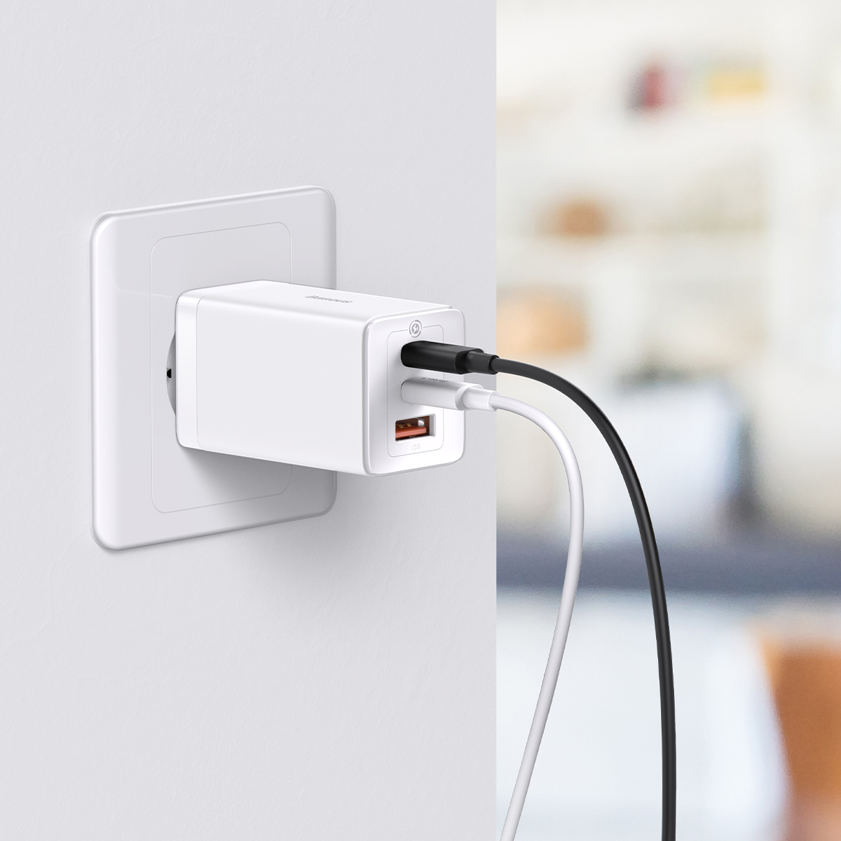 Egy fehér USB-C fali töltő a fali aljzatba dugva, fekete és fehér kábellel csatlakoztatva.