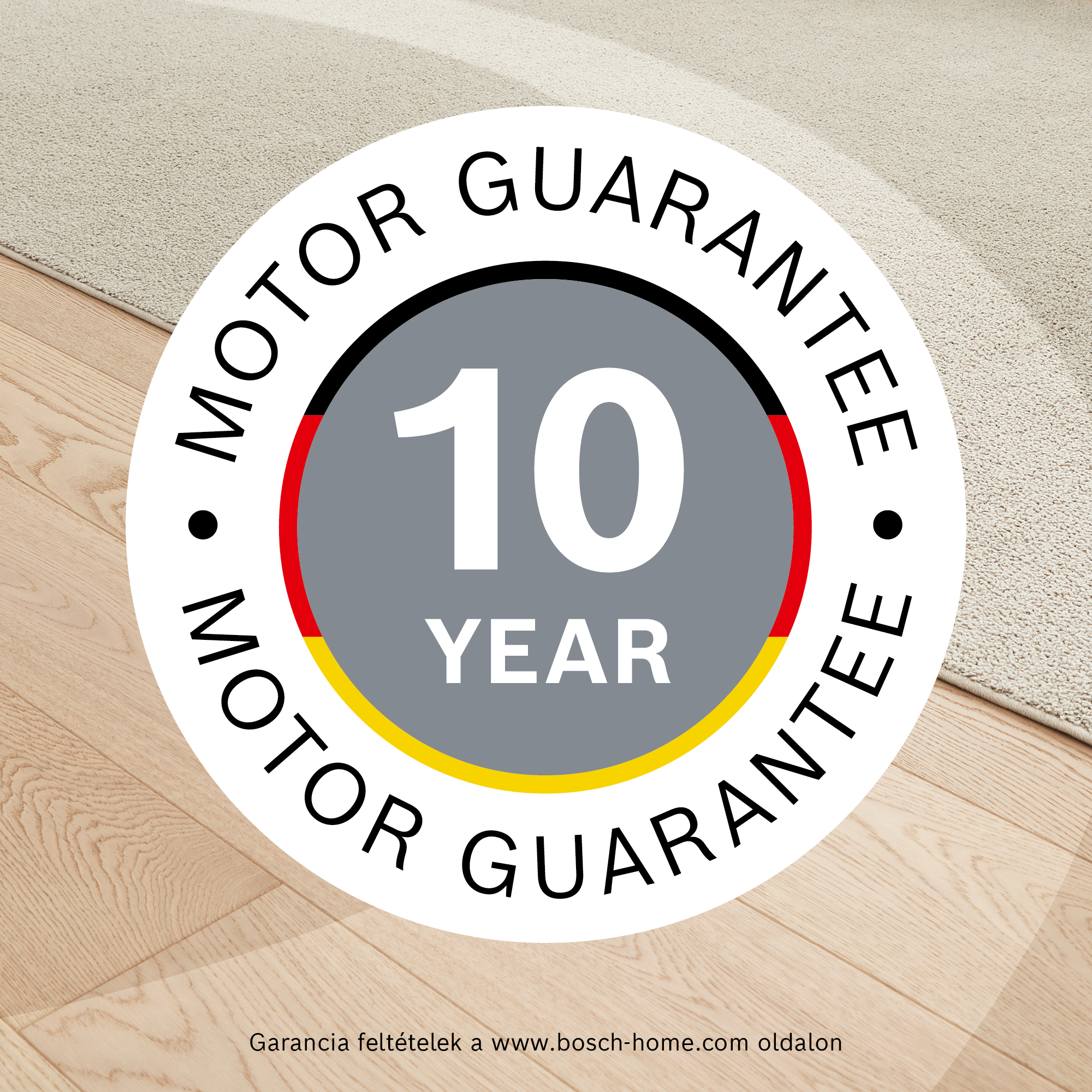 Kerek embléma '10 YEAR MOTOR GUARANTEE' felirattal fa- és szőnyegpadlón.