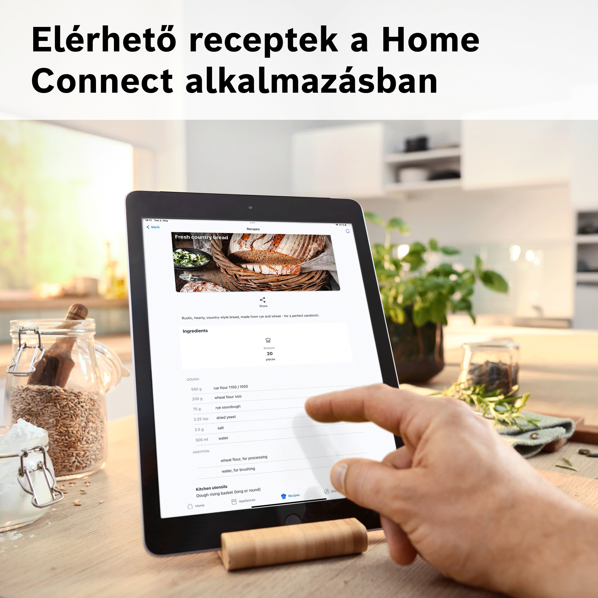 Egy tablet recepteket mutat egy konyhában, liszttel és alapanyagokkal.