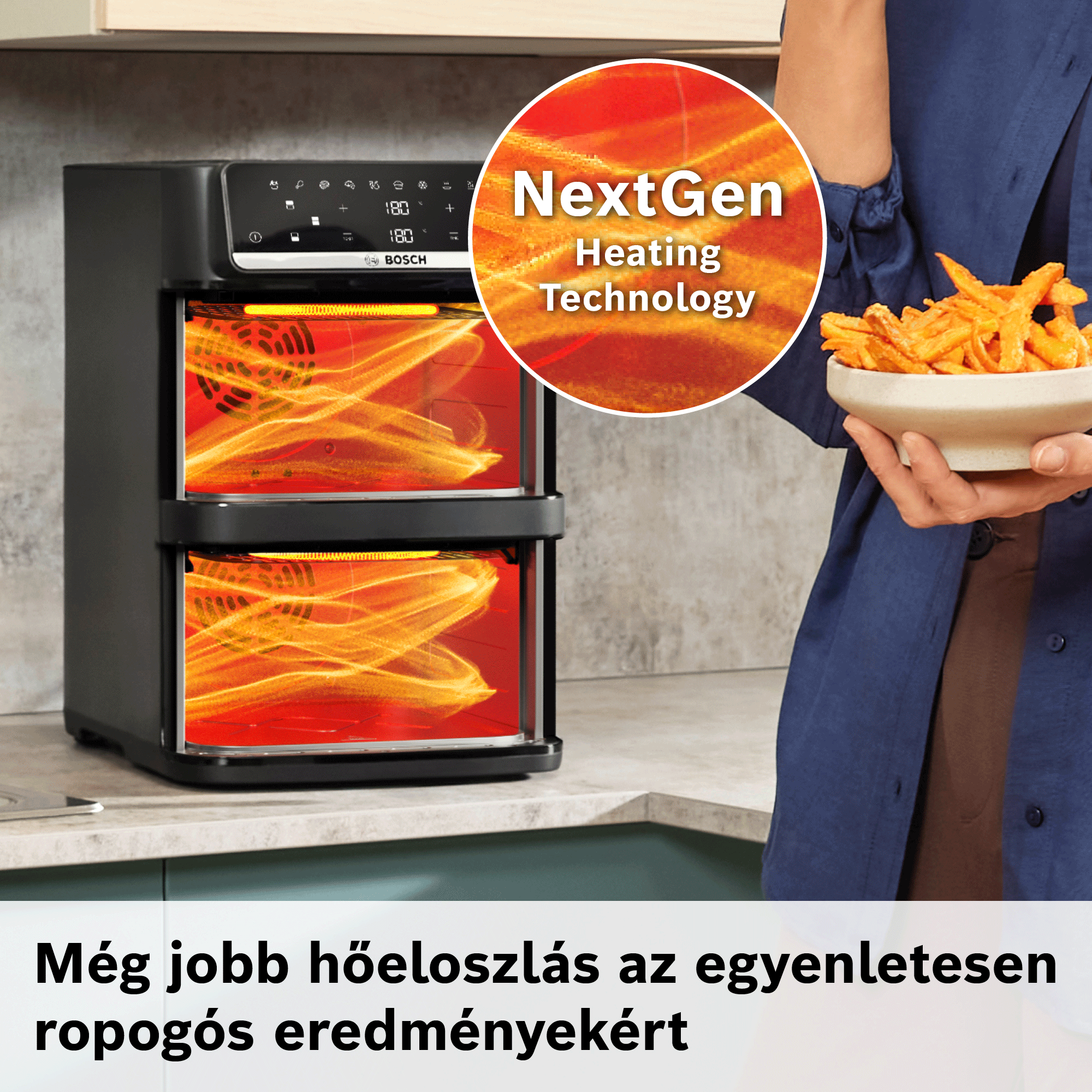 Fekete, kétszintes Bosch légsütő piros fűtőhatással, mellette egy tál sült krumplit tartó személy.