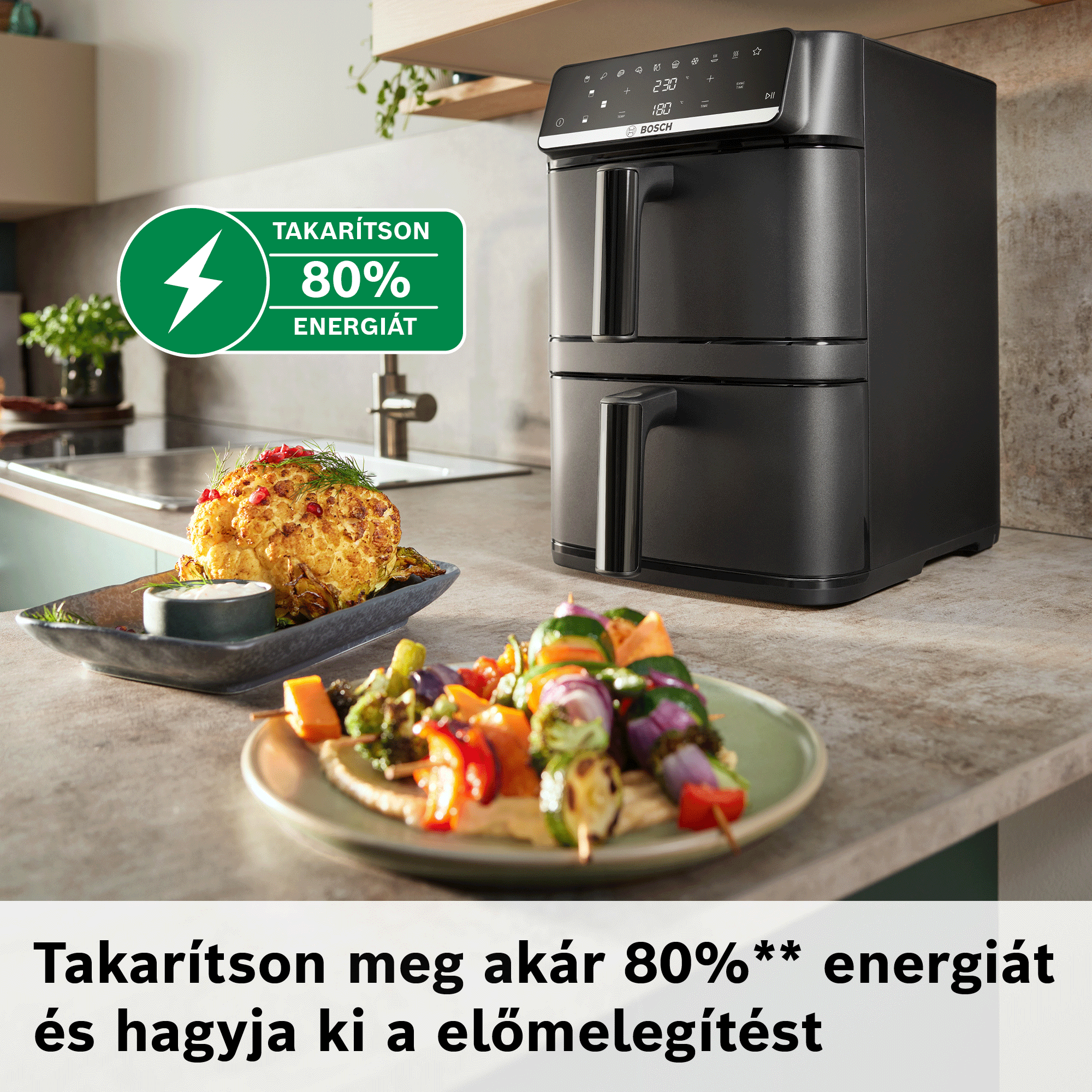 Fekete, kétkosaras légsütő konyhapulton, sült karfiollal és zöldségnyársakkal.