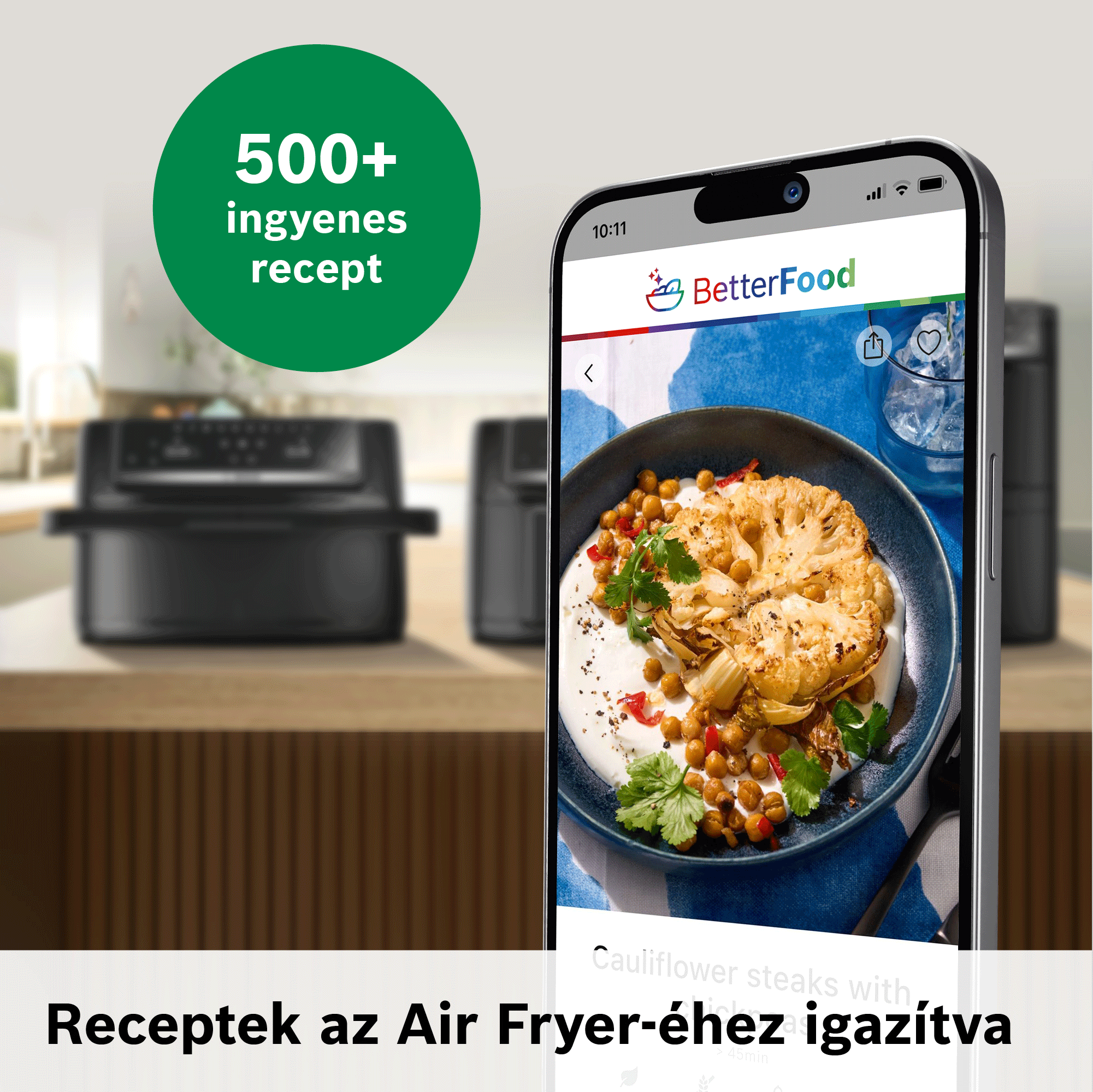 Okostelefon étel-alkalmazást mutat karfiolsteakekkel, háttérben konyhával és air fryerrel.