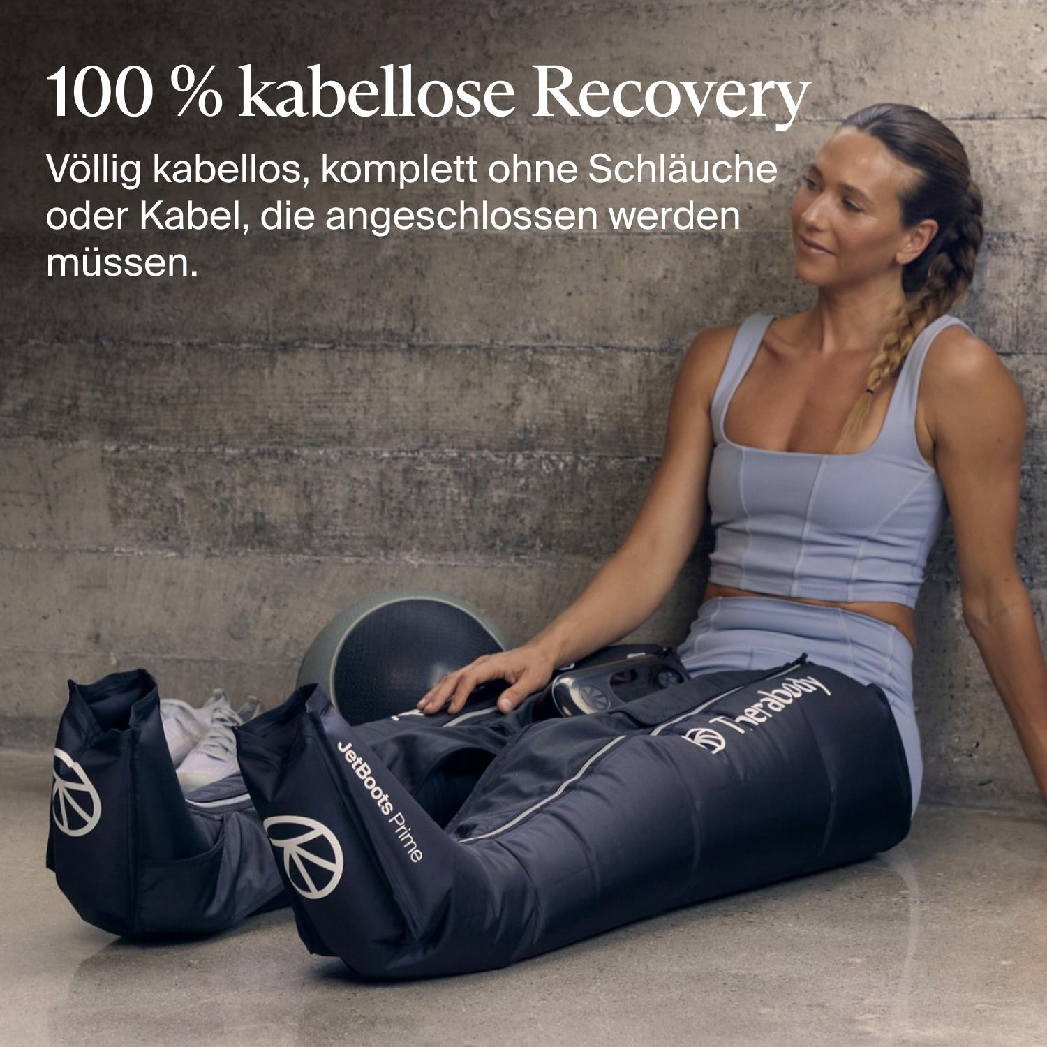 Eine Frau in Sportkleidung sitzt auf dem Boden und trägt Therabody JetBoots Prime Kompressionsstiefel.