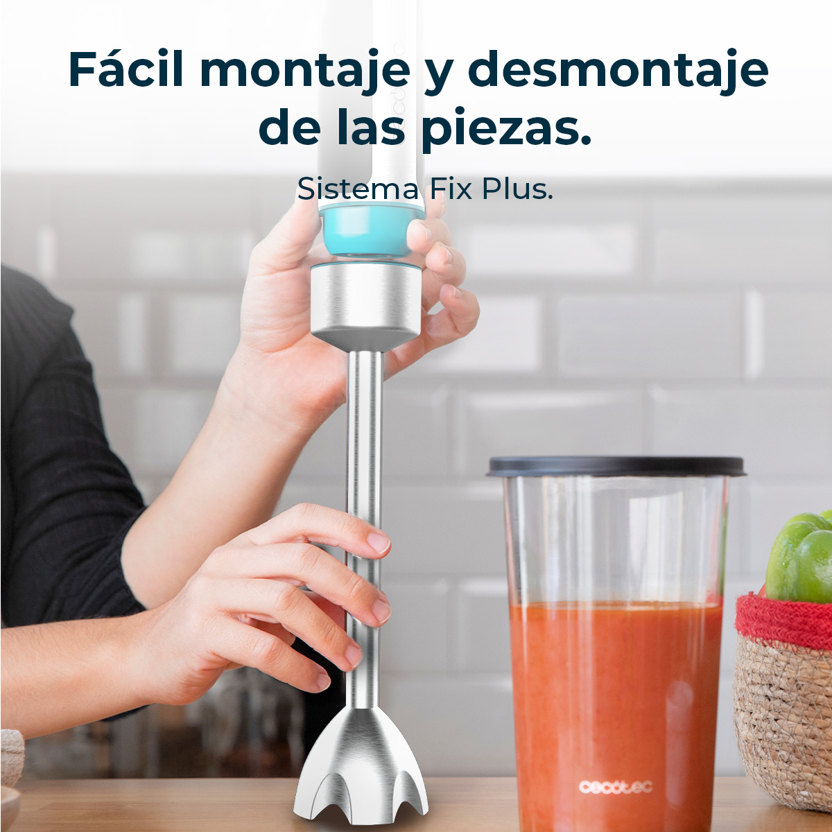 Persona ensamblando piezas de una batidora de mano, con un recipiente rojo y pimientos verdes.