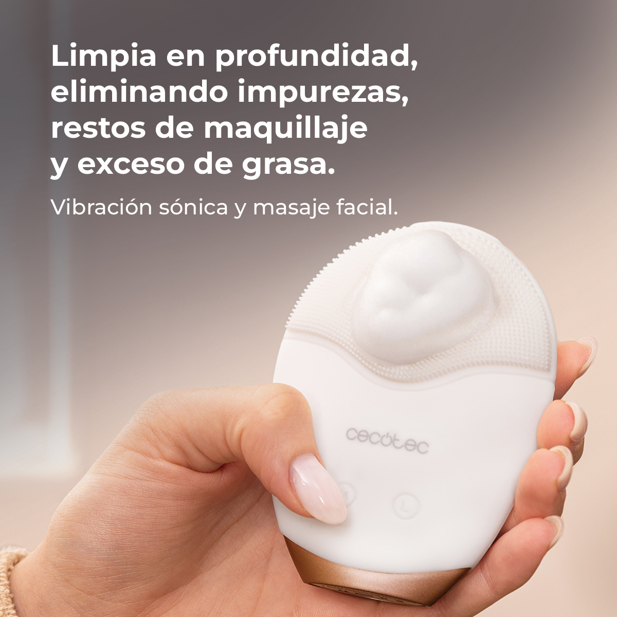 Una mano sostiene un cepillo limpiador facial Cecotec blanco con espuma y texto arriba.