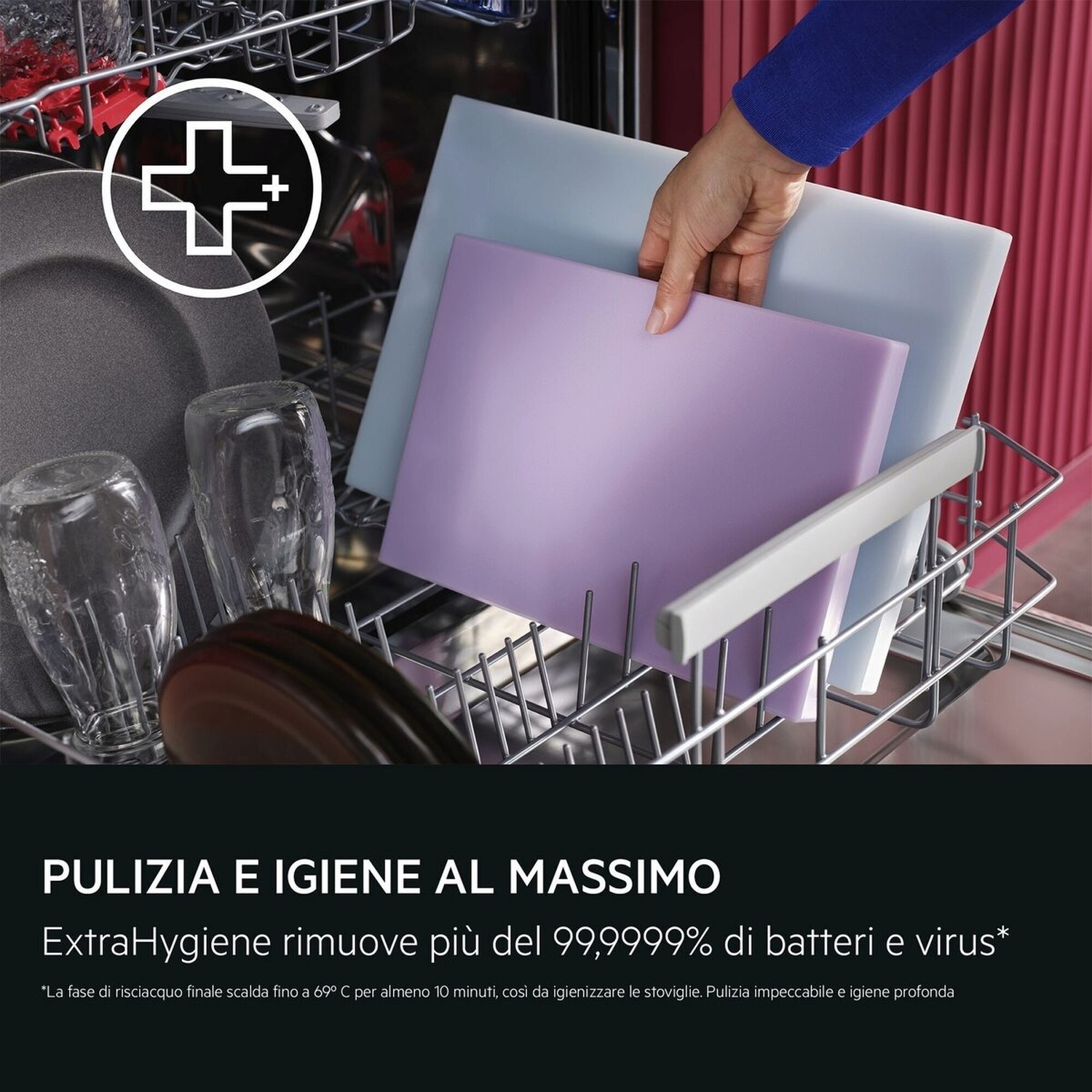 Una mano ripone taglieri colorati in una lavastoviglie aperta piena di bicchieri e piatti.