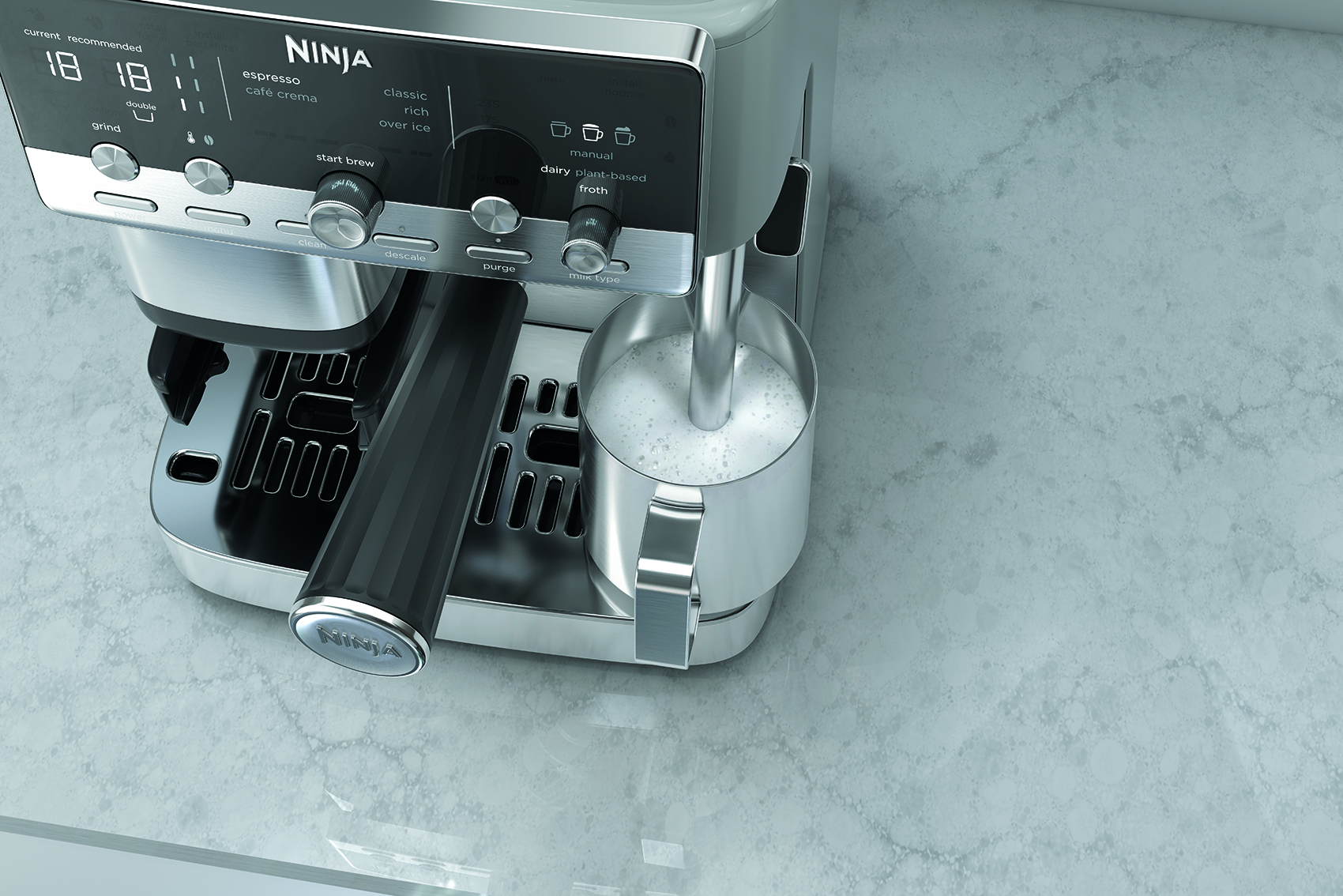 Una máquina de café espresso Ninja con una jarra de metal espumando leche en la encimera.