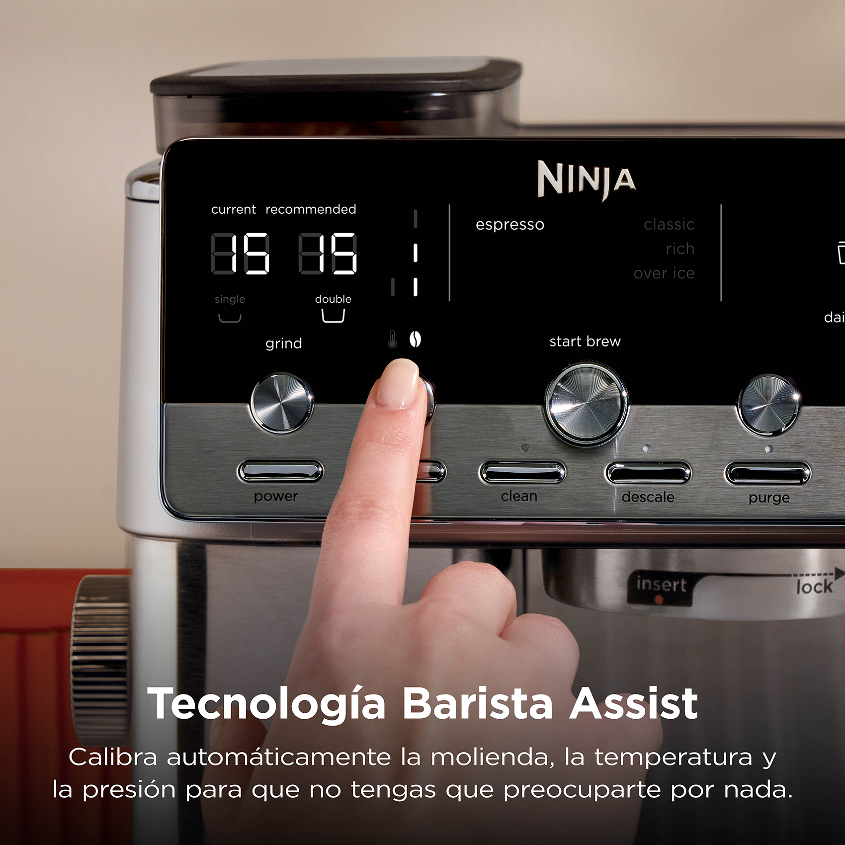 Una mano toca el panel de control de una cafetera espresso Ninja plateada con pantalla digital.