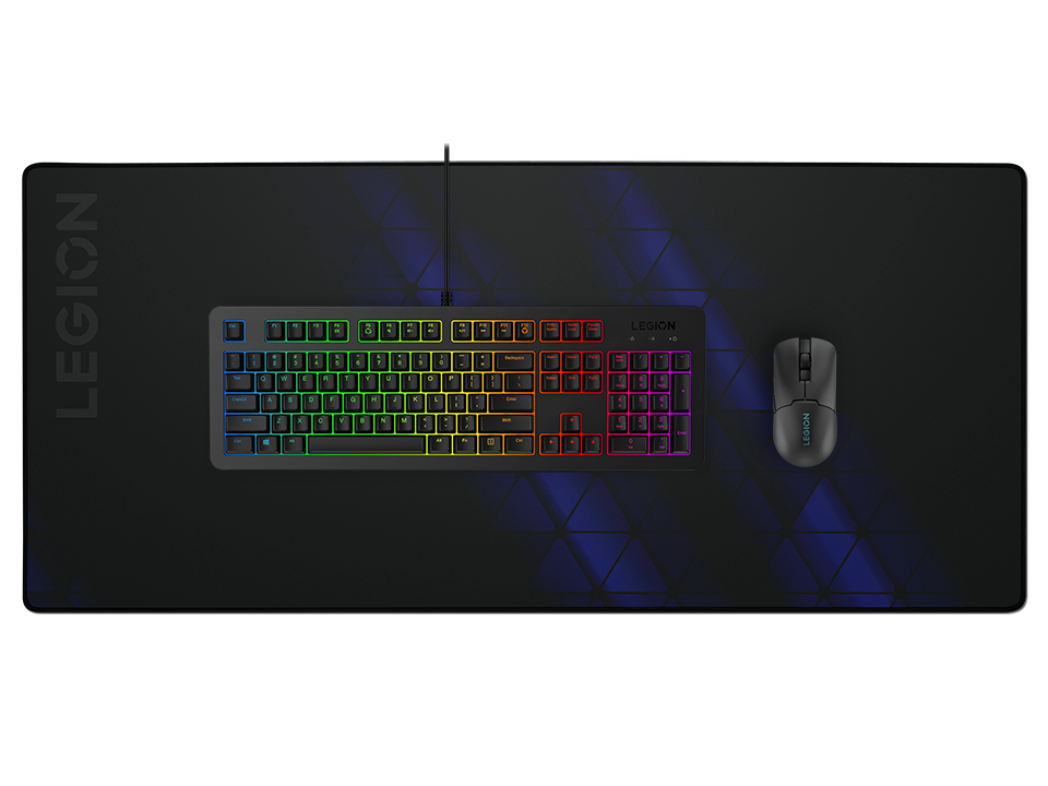 Un teclado de juego Legion negro con retroiluminación de arco iris y un ratón en una alfombrilla grande con patrón azul.
