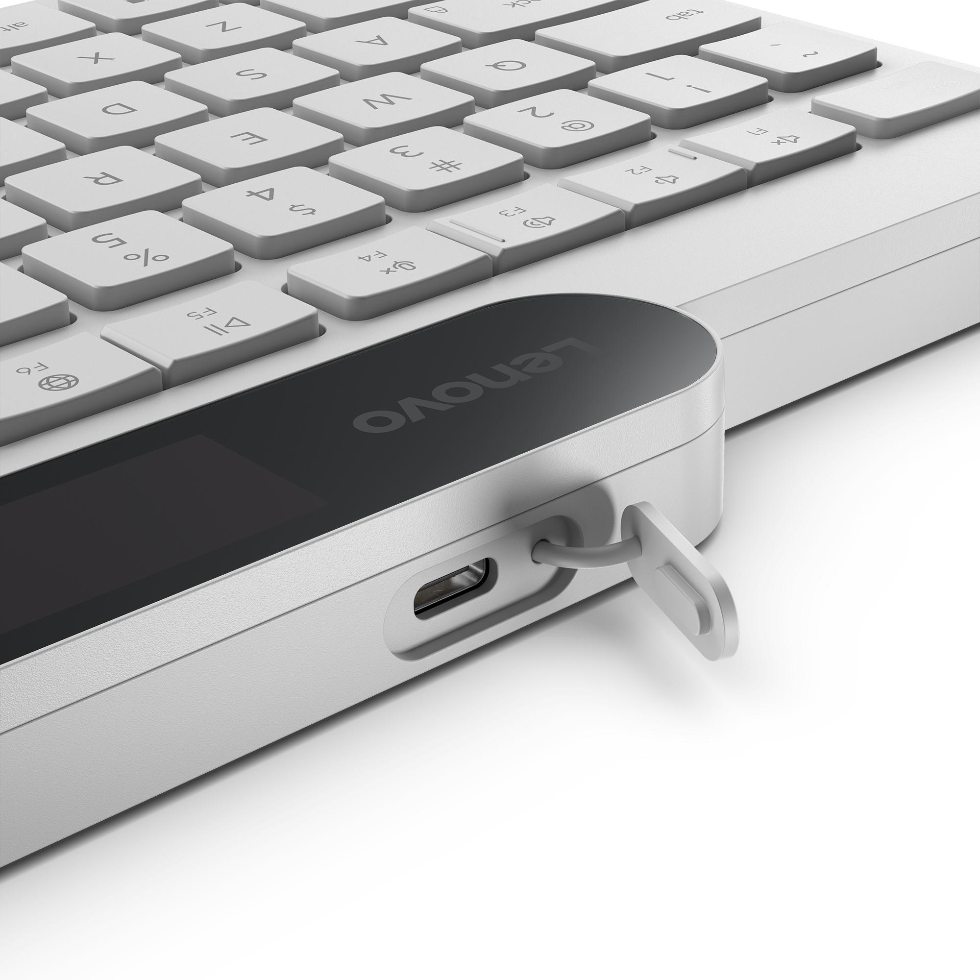 Primer plano de un teclado blanco Lenovo con un puerto USB-C abierto en el lateral sobre fondo negro.