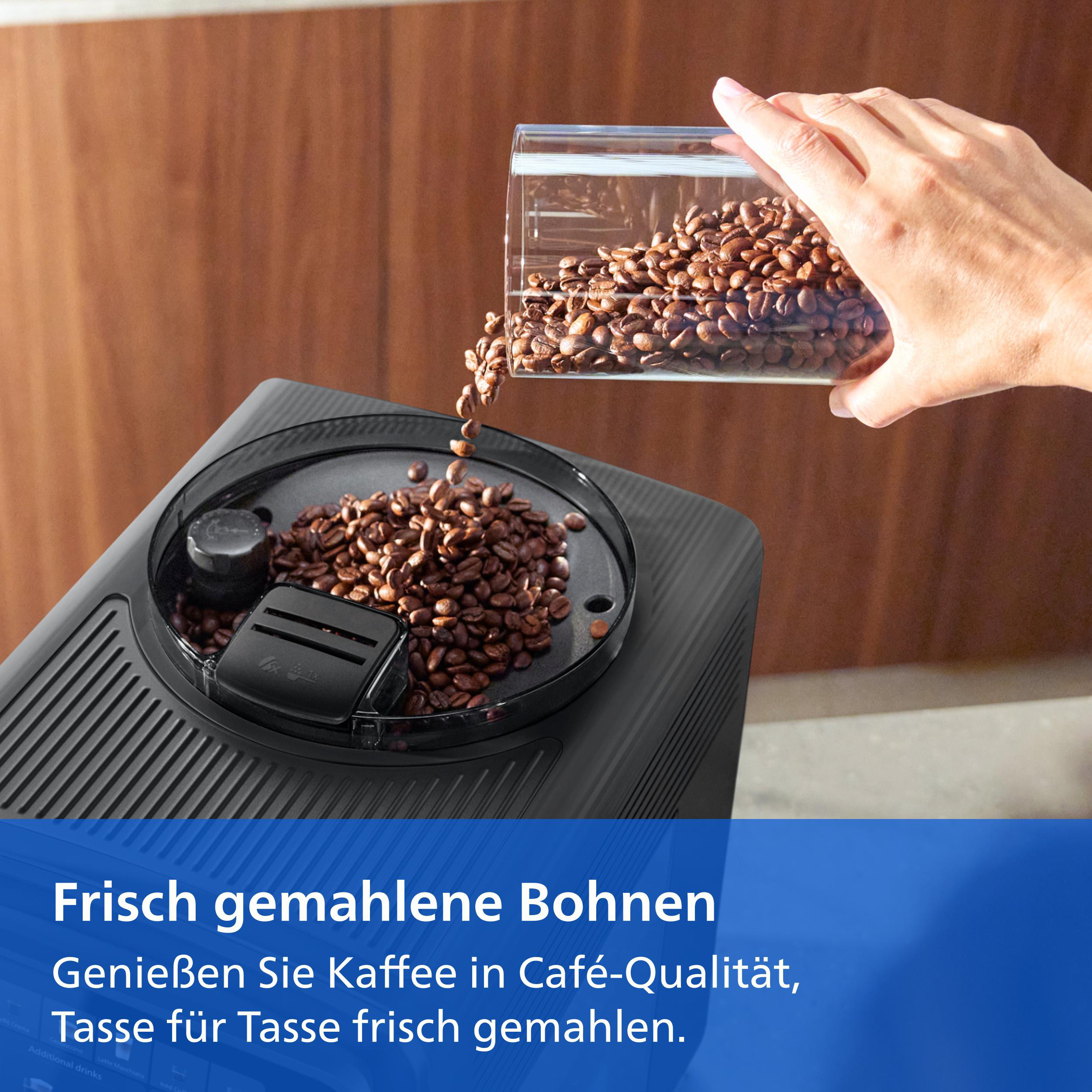 Eine Hand schüttet Kaffeebohnen aus einem Behälter in den Bohnenbehälter einer Kaffeemaschine.