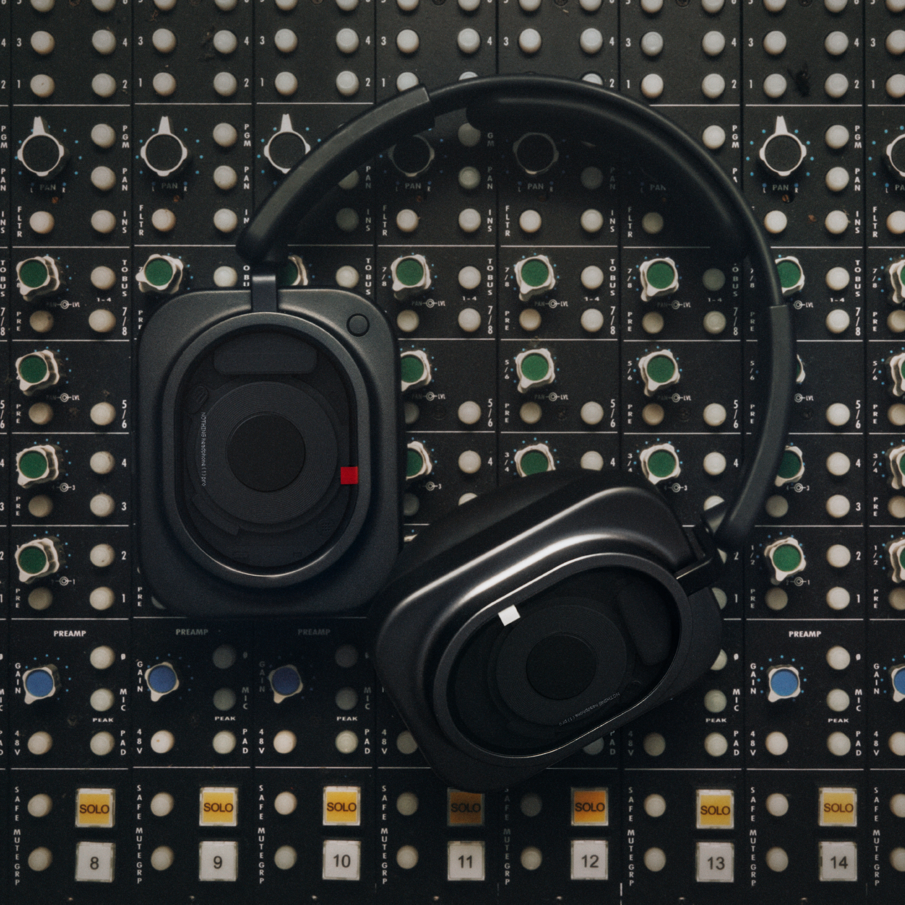 Schwarze Over-Ear-Kopfhörer auf einem professionellen Audiomischpult.