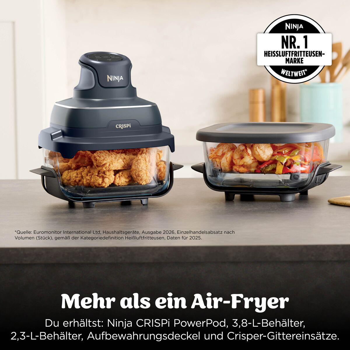 Ninja CRISPi PowerPod mit zwei Glasbehältern gefüllt mit Hähnchen und Gemüse auf einer Küchenarbeitsplatte.