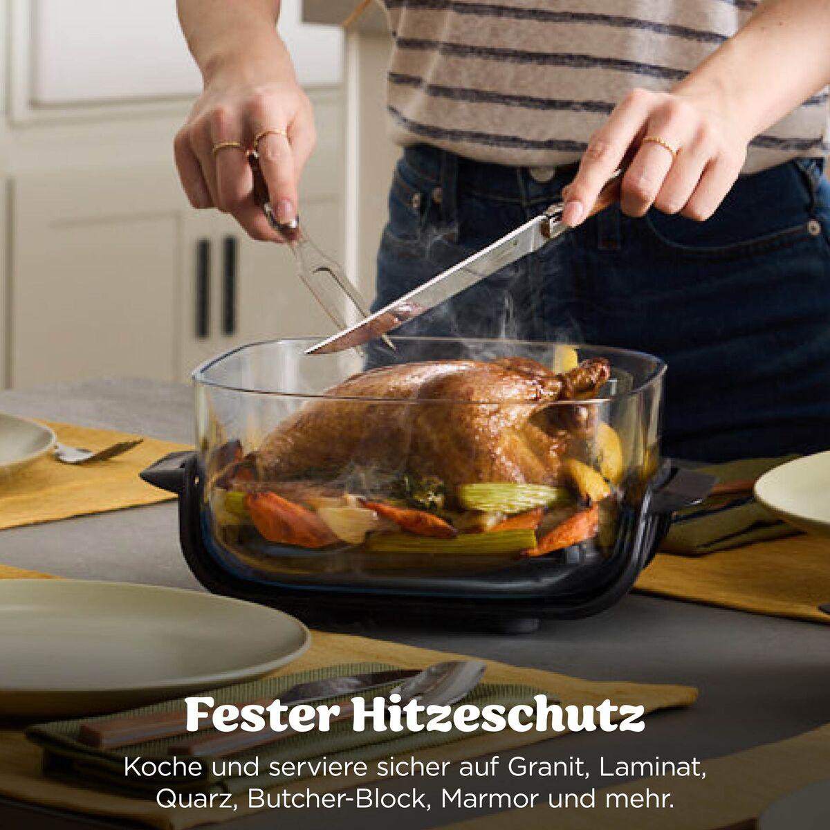 Eine Person schneidet einen gerösteten Braten in einer hitzebeständigen Glasform auf einem Tisch.