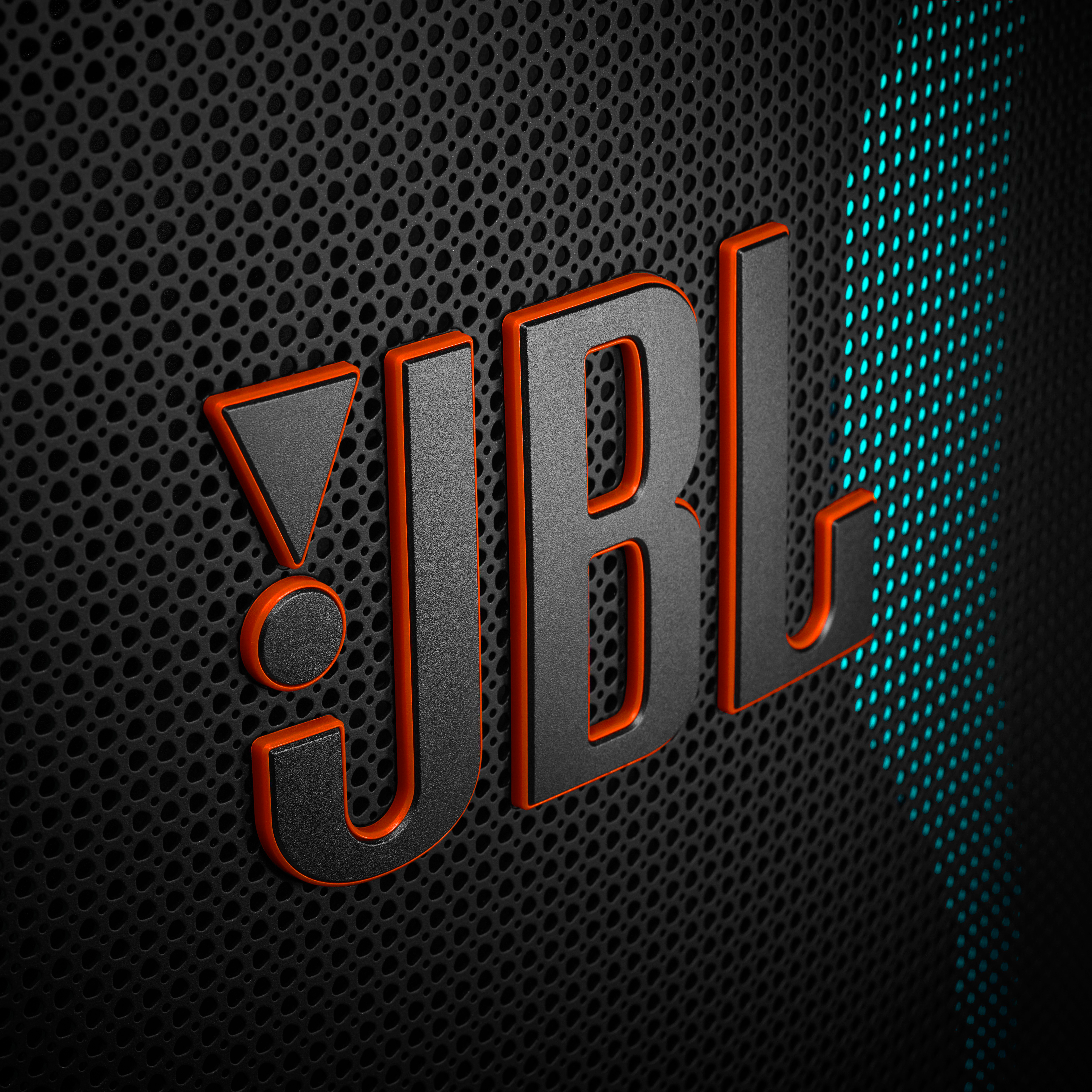 Schwarzes und orangefarbenes JBL-Logo auf einem strukturierten Lautsprechergitter mit blauer Beleuchtung.