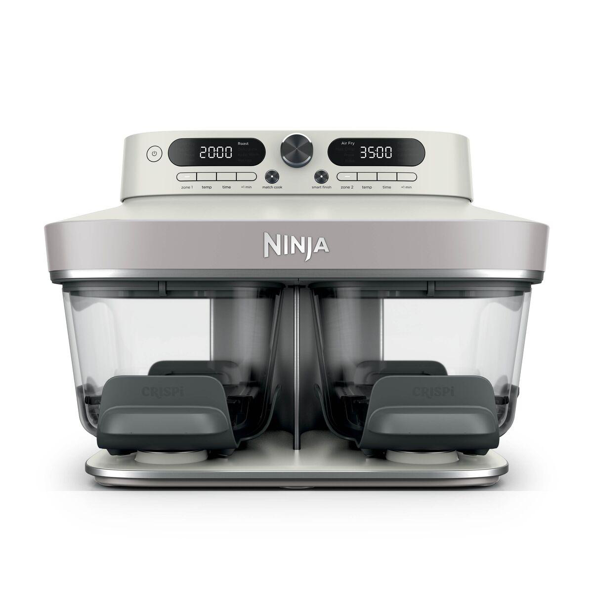 Eine graue Ninja Heißluftfritteuse mit zwei transparenten Fächern und einem digitalen Bedienfeld auf weißem Hintergrund.