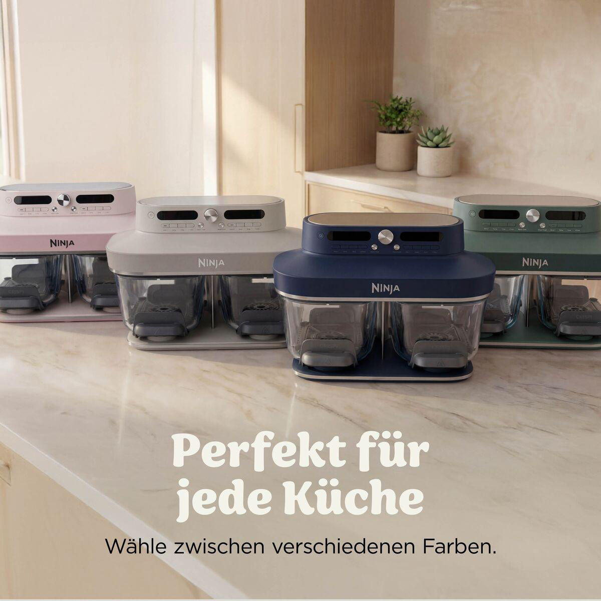 Vier Ninja Heißluftfritteusen in Rosa, Beige, Dunkelblau und Grün auf einer Theke mit Text.