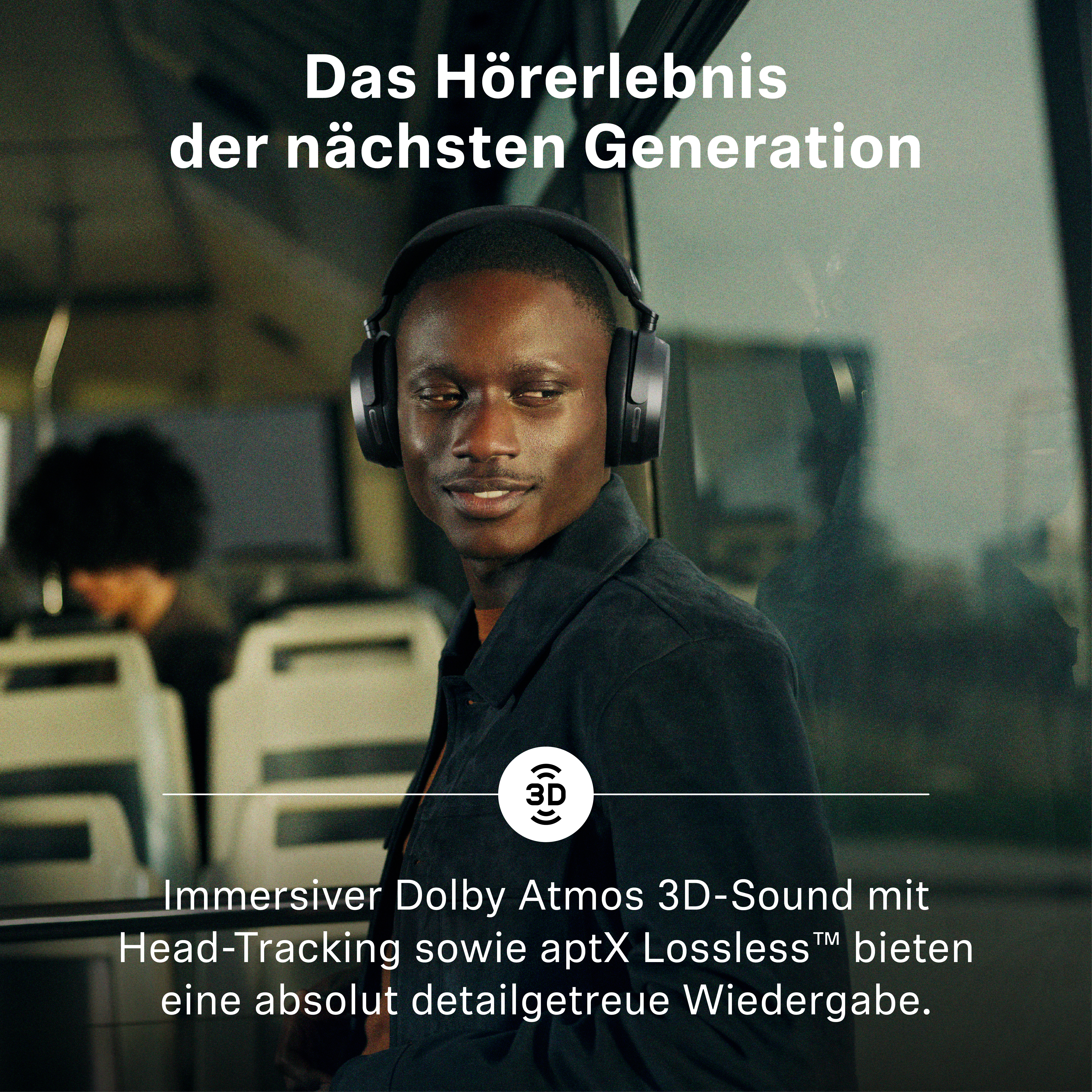 Ein Mann mit dunklem Teint trägt große, schwarze Over-Ear-Kopfhörer in einem Bus.