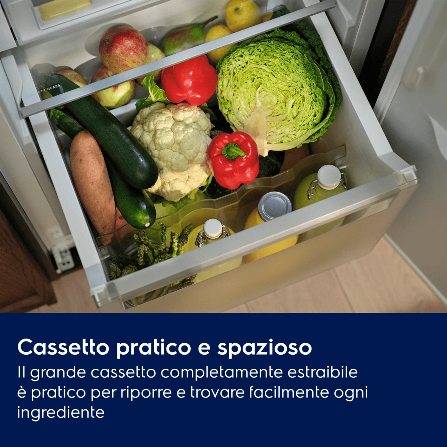 Un cassetto del frigorifero aperto pieno di verdure, frutta e bottiglie.