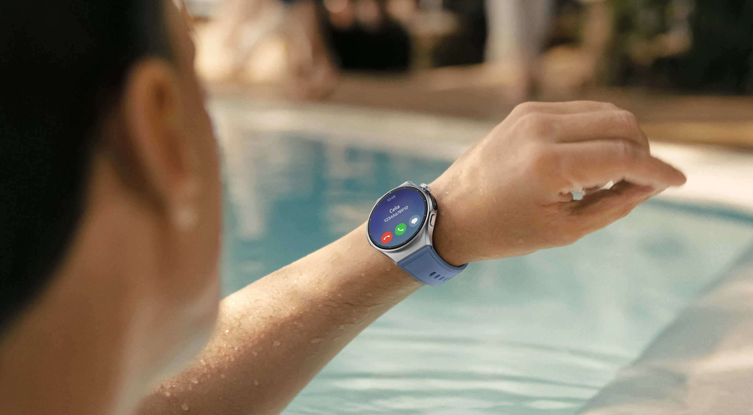 Osoba w basenie ma na sobie gładki srebrny smartwatch z niebieskim paskiem pokazujący połączenie.